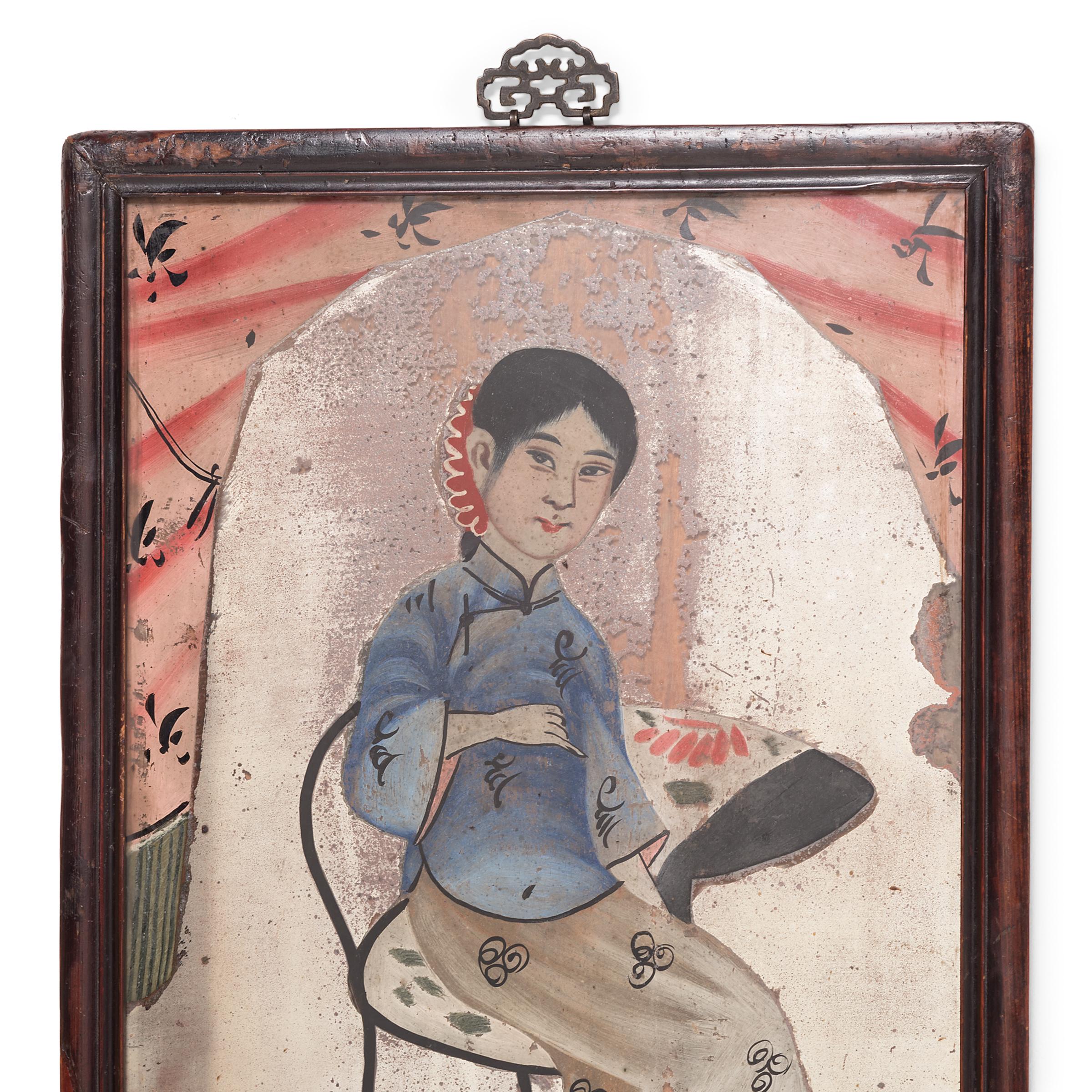 With its sparkling color and Folk Art appeal, this portrait painting from circa 1900 makes a delightful accent to a bedroom or study. This portrait painting of a young woman is an example of reverse glass painting, in which an artist applies paint