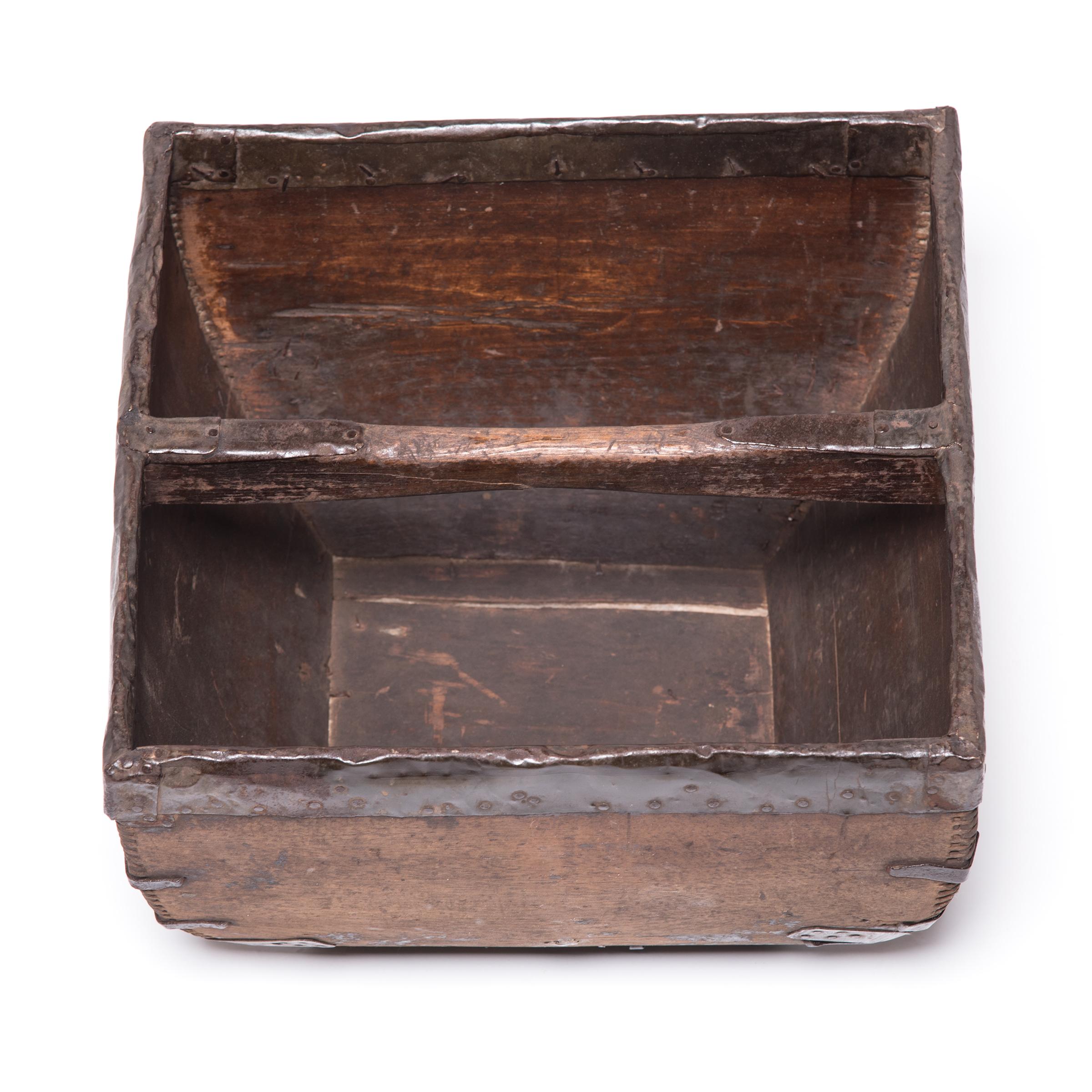 This rustic container was made over a hundred years ago to measure and hold a dou of rice, an ancient Chinese measurement. It is handcrafted with dovetail joints, iron-finished edges, and a hand-arched handle. An unusual amount of care was taken by
