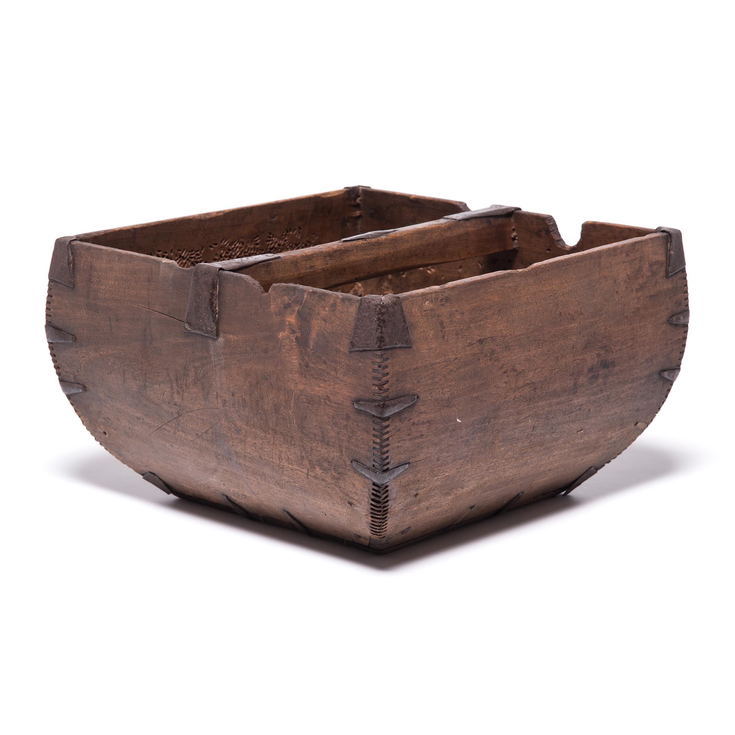 This rustic container was made over a hundred years ago to measure and hold a dou of rice, an ancient Chinese measurement. Hand-crafted with dovetail joints, the vessel has gracefully swelling sides and an arched handle, burnished from years of use.