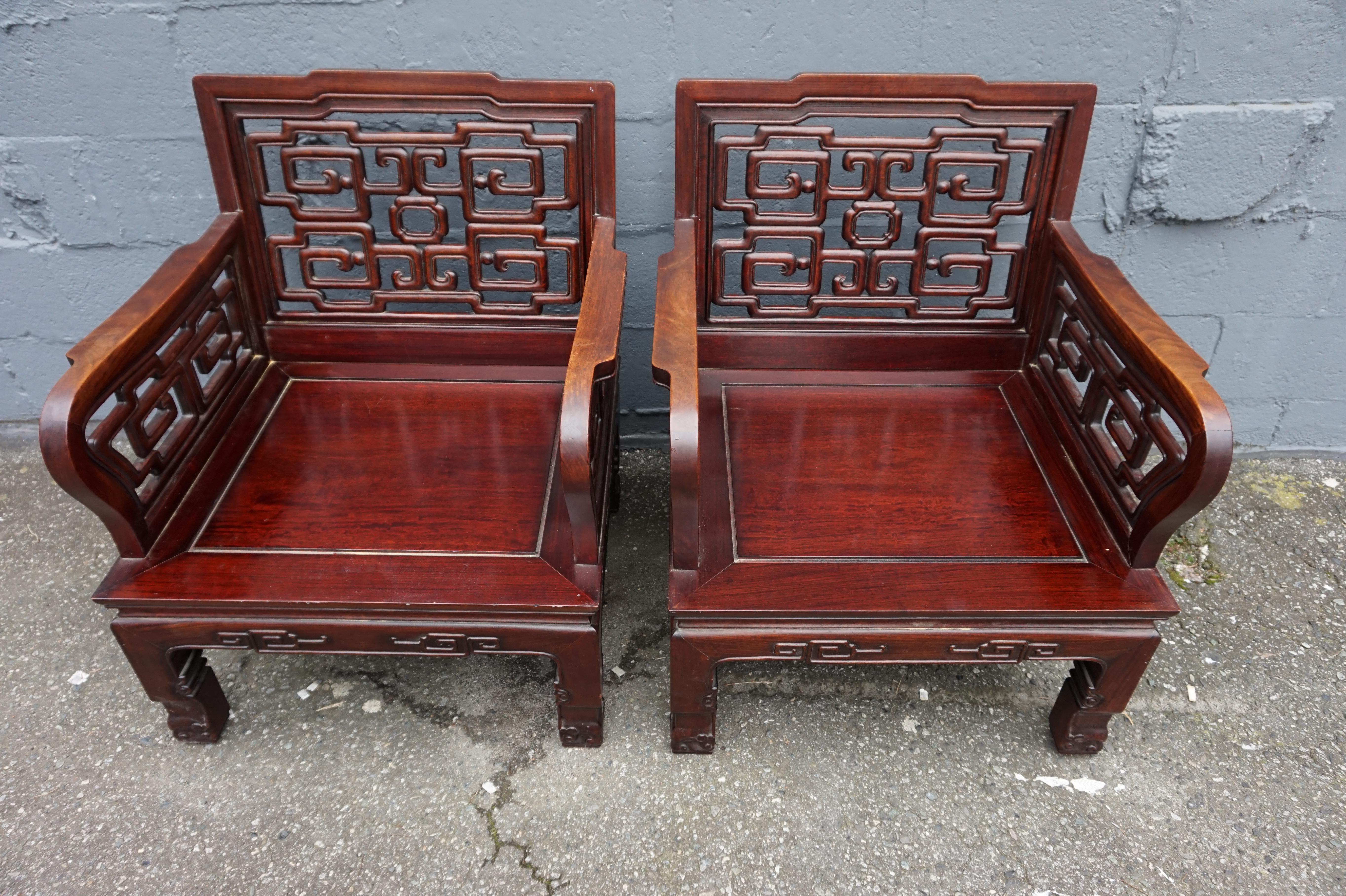 Beautifully hand-carved and well proportioned Chinese solid Rosewood export chairs. Sturdy with refined carving and broad armrests. In good original condition. Ideal for a space that requires a touch of Asian flair or simply seating that exudes