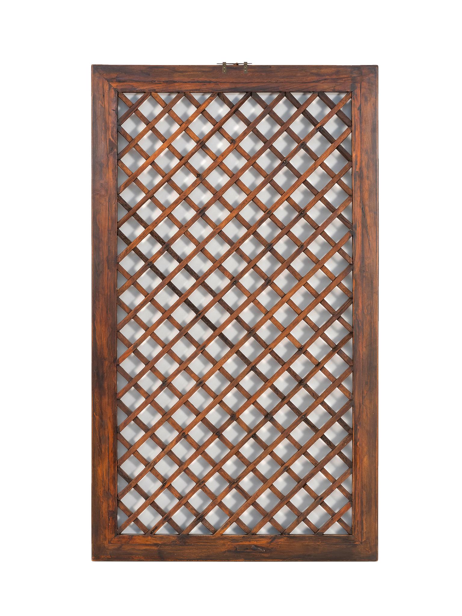 A beautiful Chinese screen, early 20th century. Crafted from rosewood with a rich, honey red-brown tone. The openwork design is an elegant lattice pattern with an ogee frame. This screen is well-aged giving the wood character and a warm quality. A