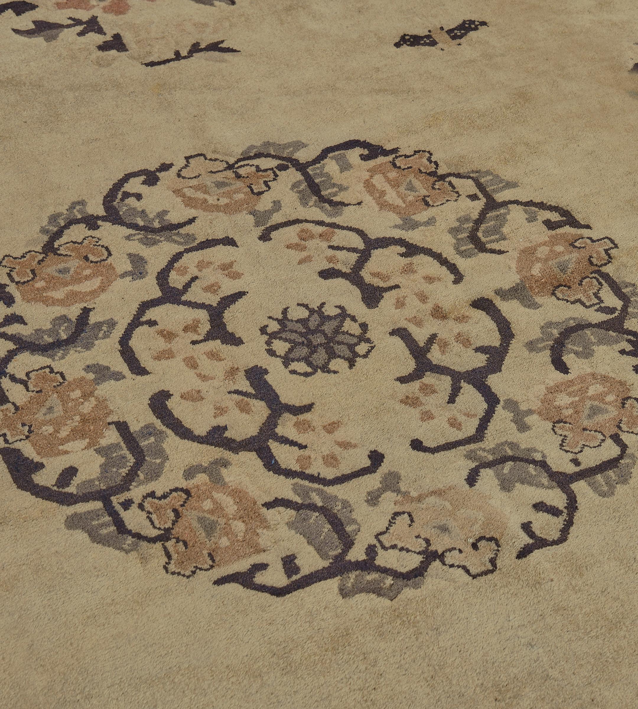 This traditional hand-woven Chinese rug has a muted beige field of sparse flowering vines, pagoda icons, and geometric wreaths, enclosing a delicate floral rounded medallion, with scrolling delicate floral spandrels, in an elegant medium gray