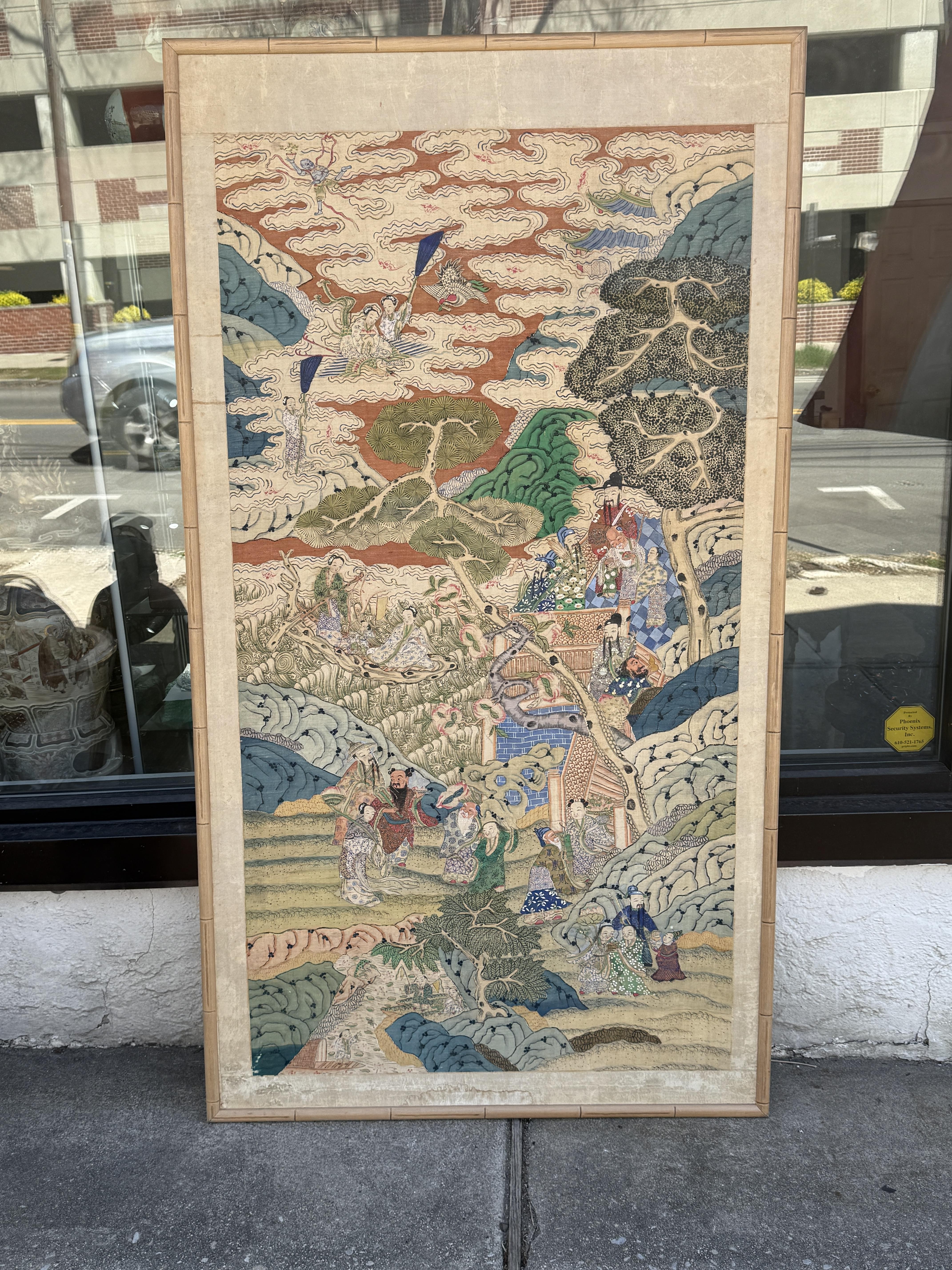 An impressive early 20th century Chinese silk kesi panel measuring 74 x 40 inches, finely woven with vibrant and detailed imagery of immortals and attendants set within a heavenly landscape. The scene unfolds vertically through rolling clouds,