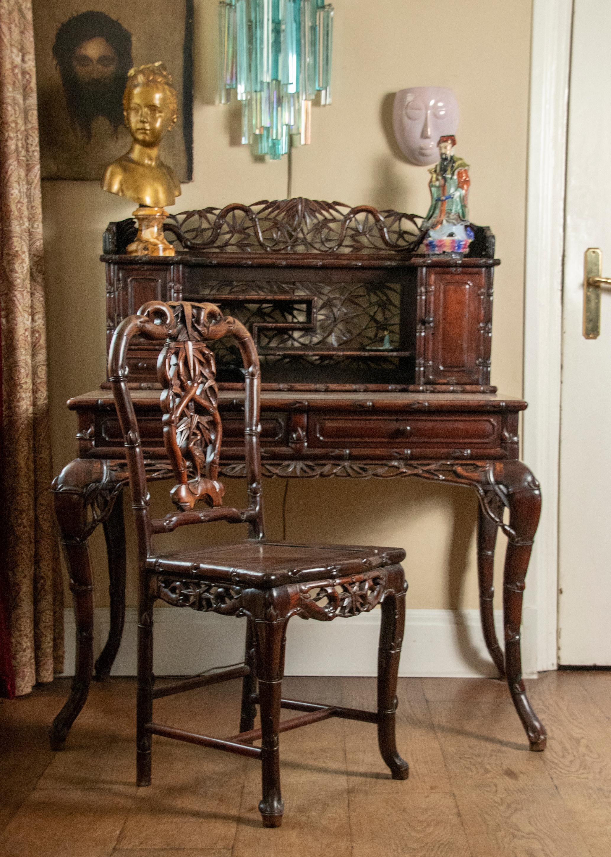 Beautiful desk set, made of the Chinese hardwood type Hongmu. The set comes from Hong Kong and is made for export to Europe. The desk and chair have very rich carvings of bamboo motifs. The set was made around 1900. What is special about this set is