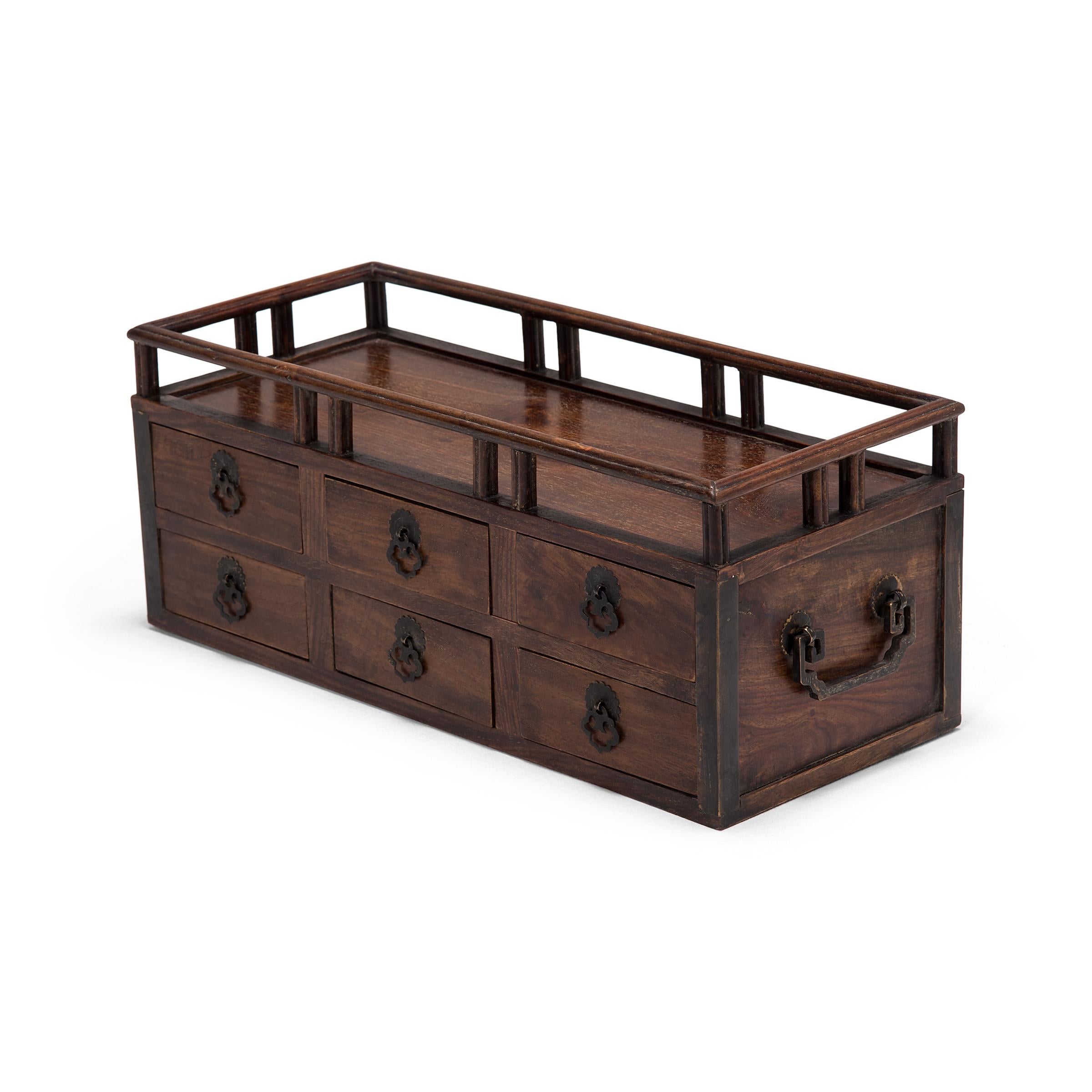 Crafted of fine rosewood, this early 20th century scholars' chest is an example of the multifunctional boxes used tabletop in lieu of a chest of drawers. While some were used to store cosmetics, jewelry, documents, and other accessories, the small
