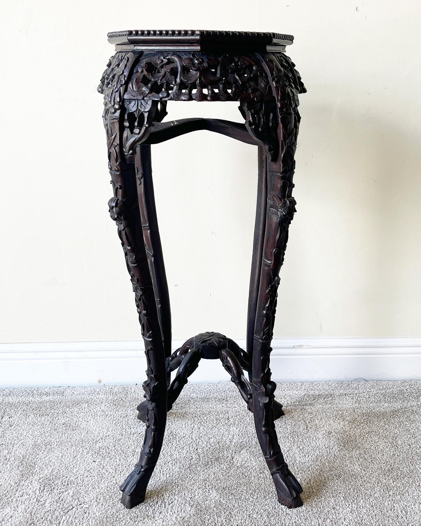 Octagonal Teakwood Stand with Pierced Carved Apron, And inset Marble Top. Cabriole Legs with Stretchers are all intricately carved with floral designs. Marked underneath the marble with Chinese writing/stamps

Table face measures
13x13x35”.
