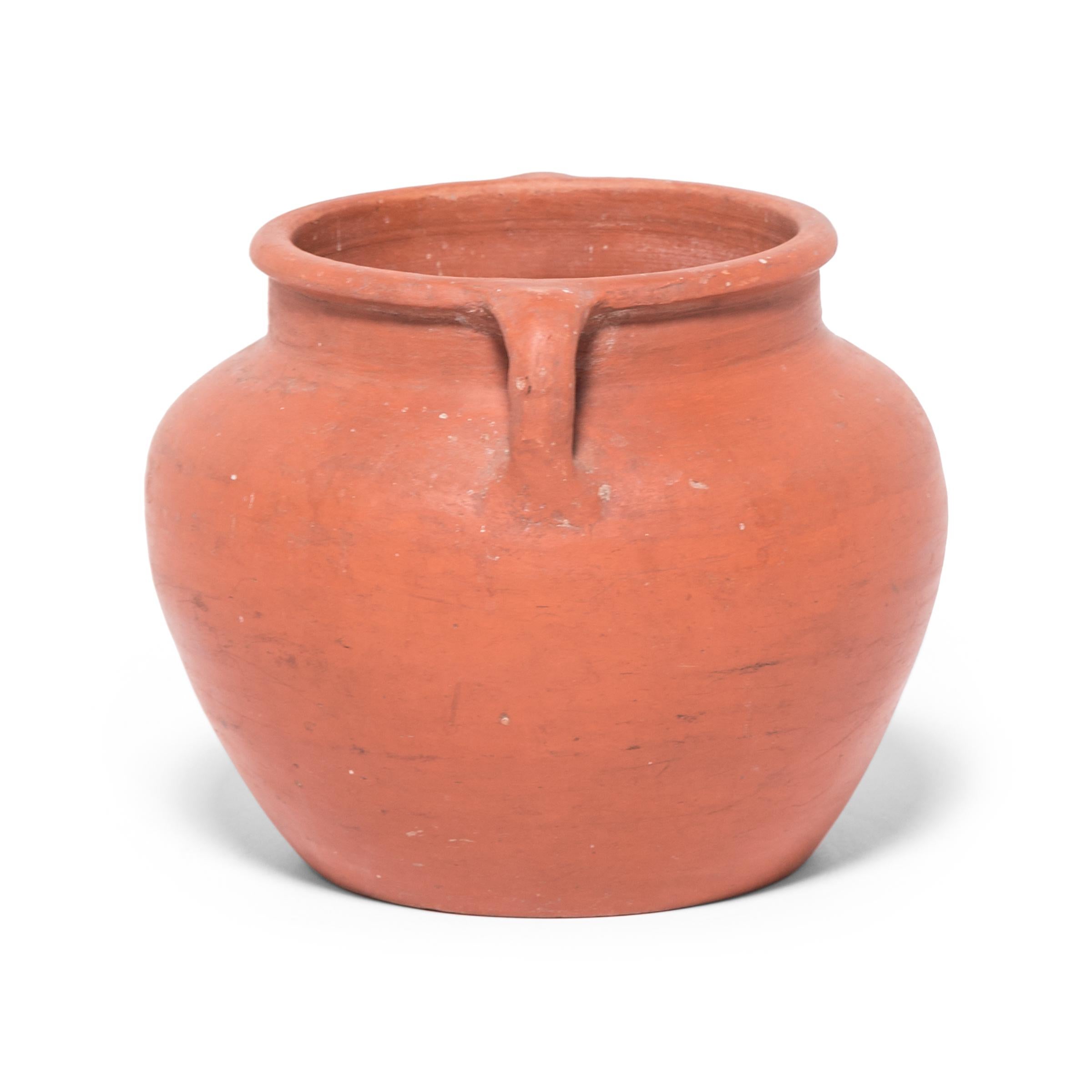 Based on vessels fired in ancient Chinese kilns, this jar's perfect proportions haven't changed much since the Bronze Age. Keeping in the tradition of its predecessors, this early 20th-century ceramic vessel is glazed with a slip of red clay,