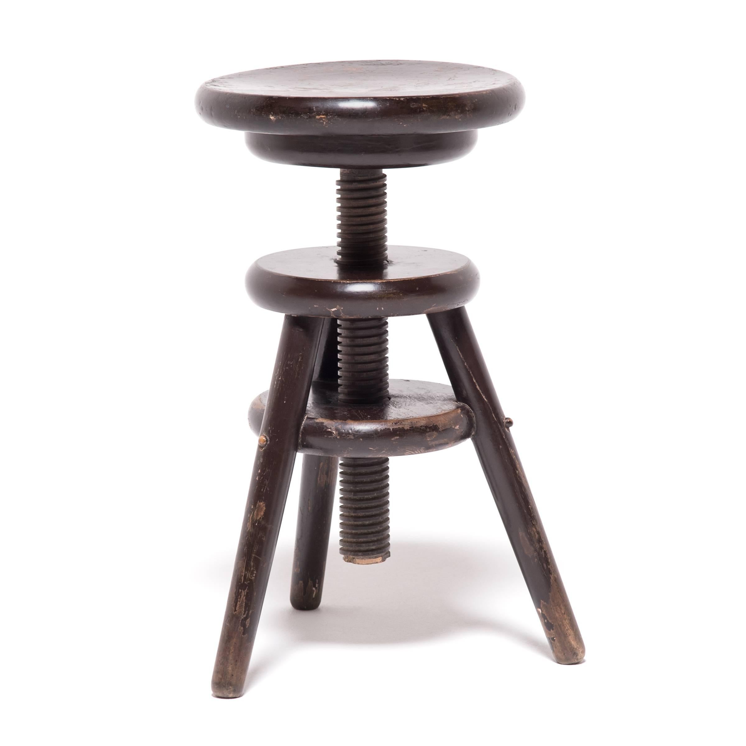 It is unusual to see an early 20th century Chinese round stool with adjustable height. The artisan who created this inventive stool hand-carved the cylindrical center post for easy adjustment. Soundly held together with masterful mortise and tenon
