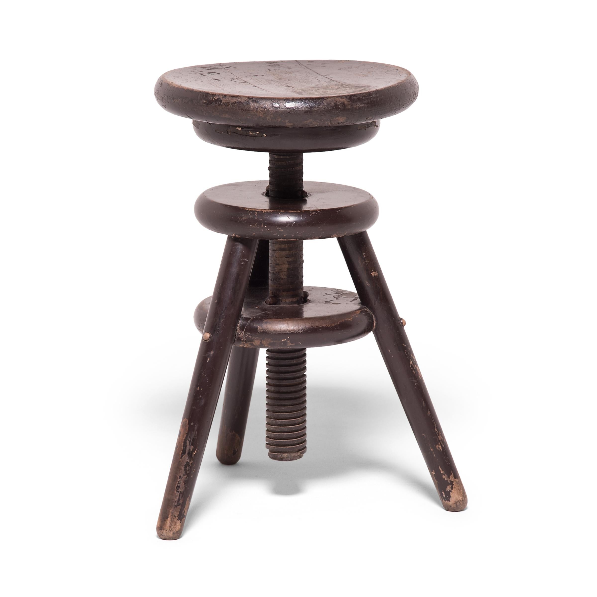 It is unusual to see an early 20th-century Chinese round stool designed to be adjustable. The artisan who created this inventive stool hand-carved the cylindrical center post for easy adjustment. Although this stool can no longer swivel, it remains