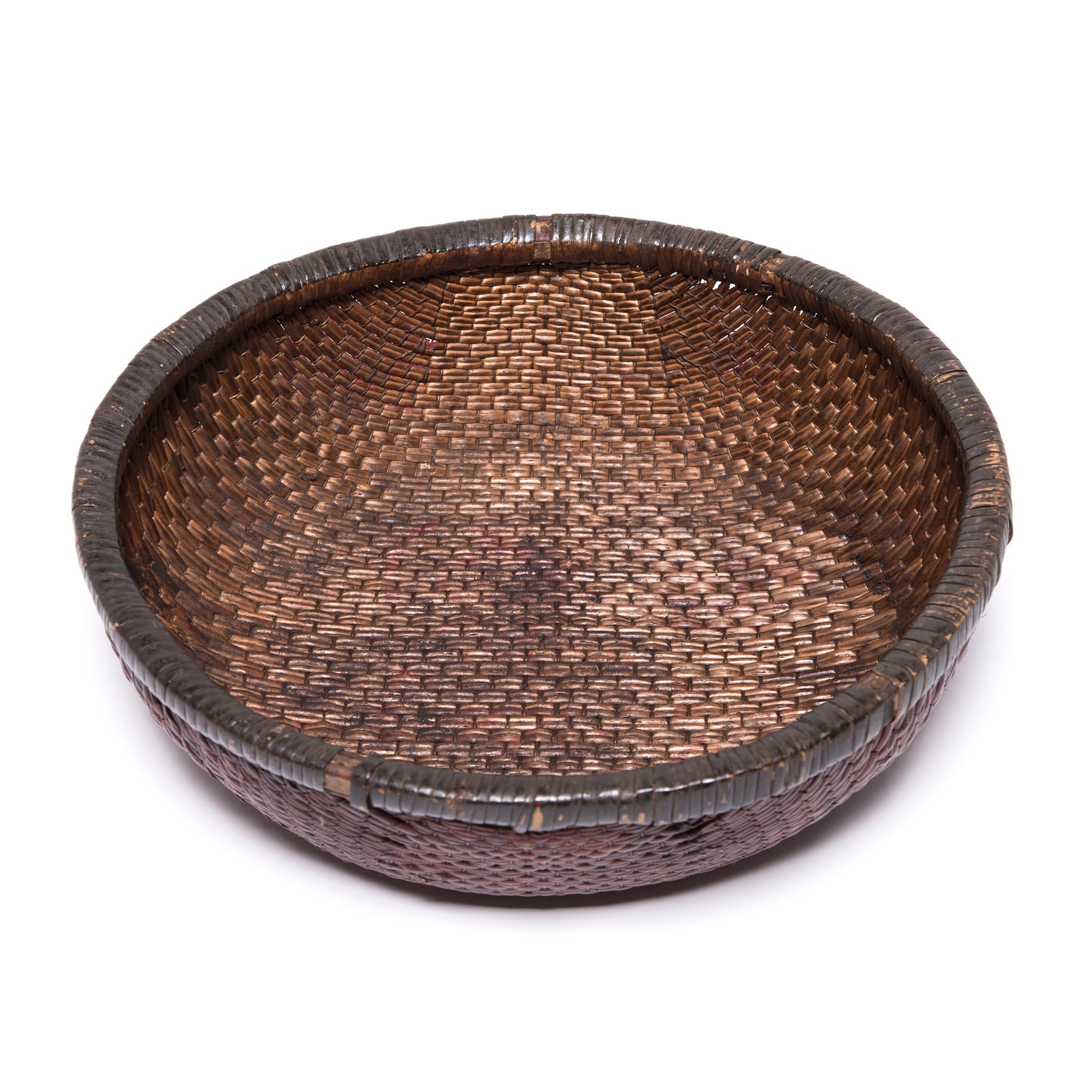 Tightly woven of natural reeds, this neat basket likely contained offerings of food, money, and fruit presented as part of ritual ancestor worship on a family altar. Over the course of the past century, the basket's deep color has developed