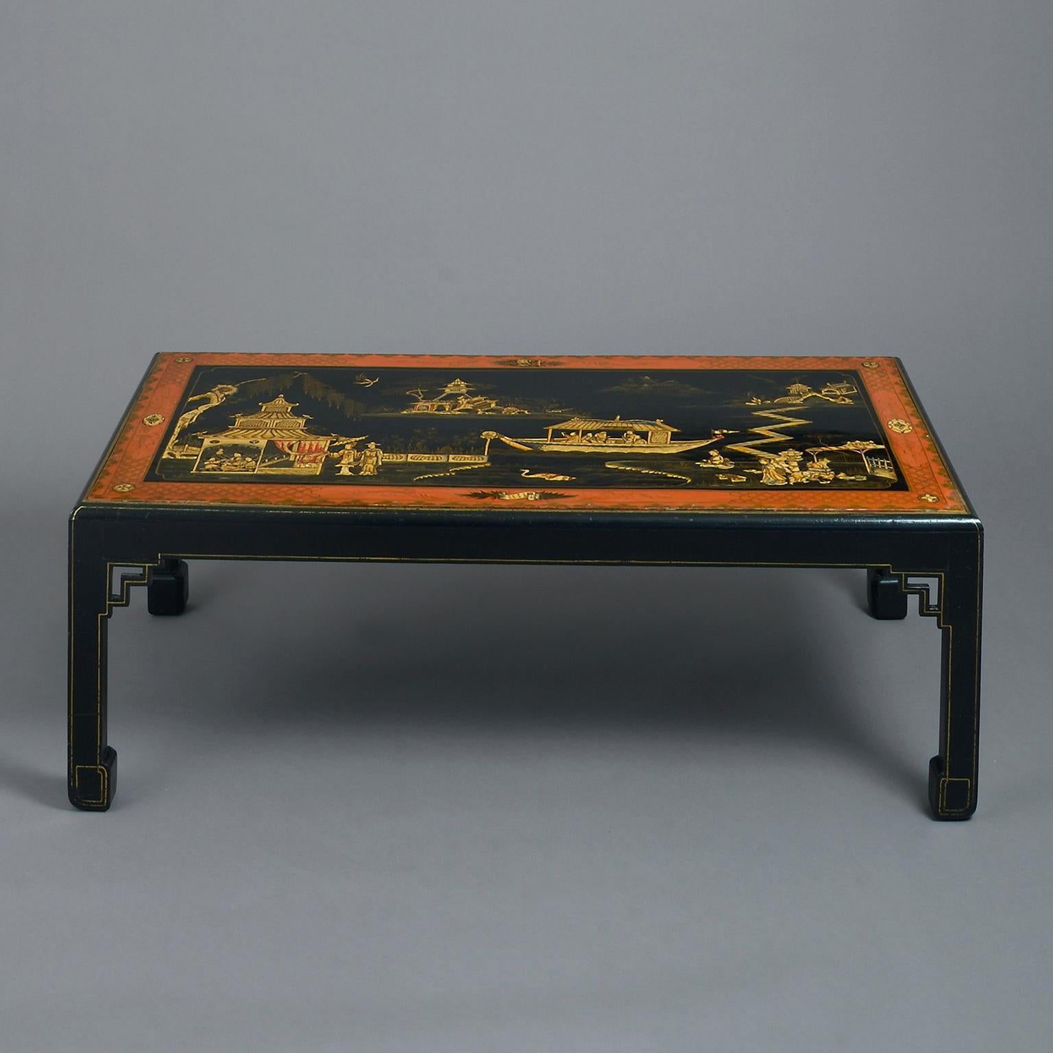 An early 20th century Chinese lacquer coffee table or low table finely decorated with figures, pagodas, boats and birds on a black ground, within a border of russet red; raised on square legs with fretwork spandrels.