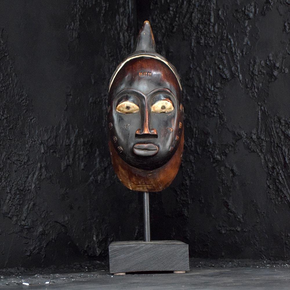 Early 20th century African Mask 
An early 20th Century example of a  African mask in the form a young woman, with facial scared markings which represent her age and tribe identity. With strap holding holes either side and a wonderfully carved ornate