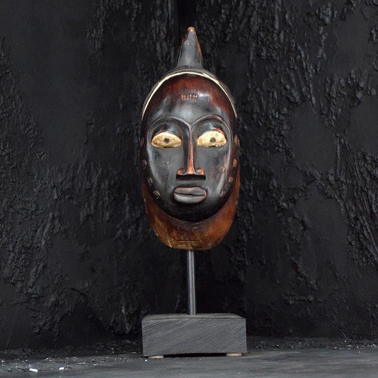 Early 20th century Chokwe Mask 
An early 20th Century example of a Chokwe African mask in the form a young woman, with facial scared markings which represent her age and tribe identity. With strap holding holes either side and a wonderfully carved