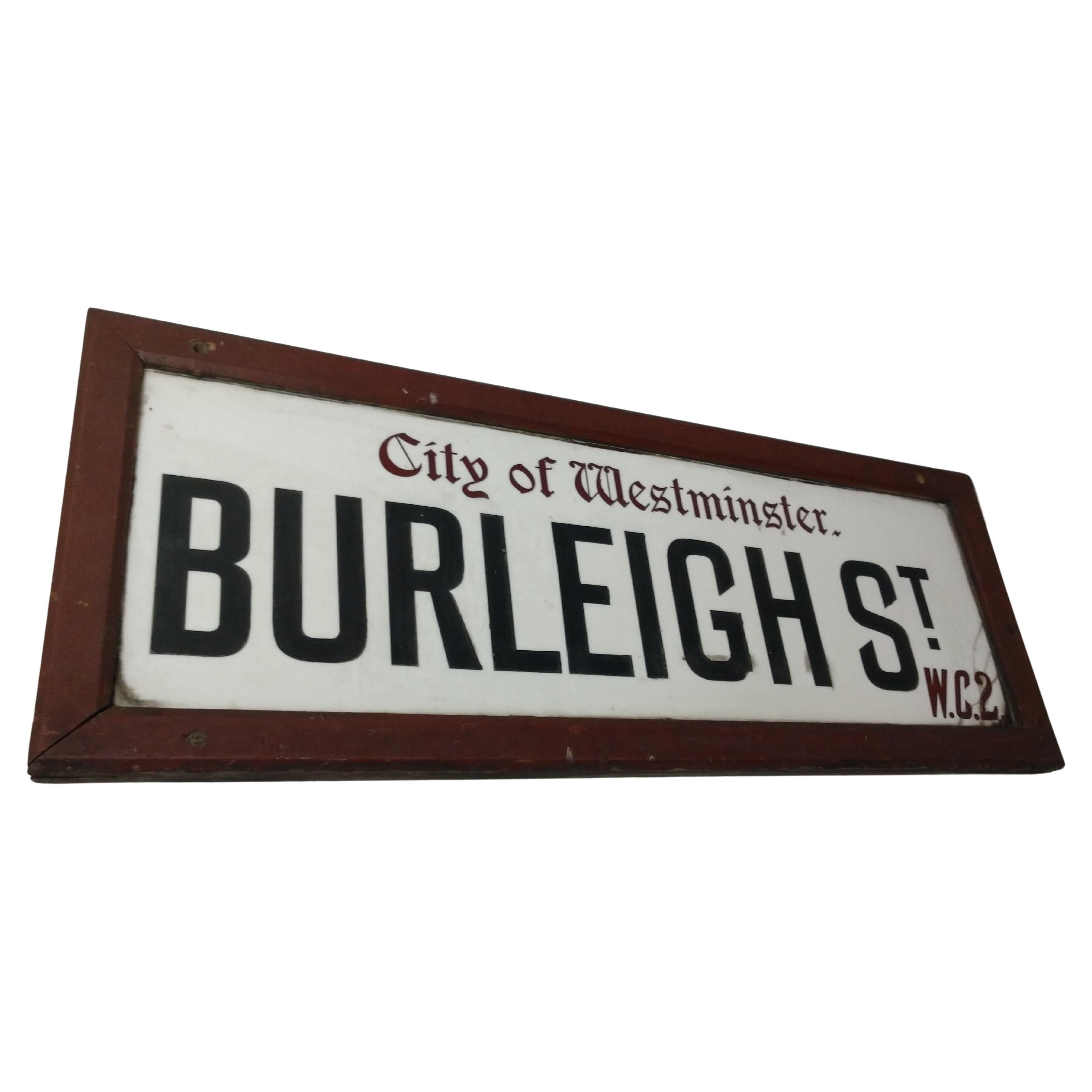 Fabulous early milk glass street sign from the City of Westminster London. Original wood frame in excellent vintage condition. A couple of cracks in the glass on right lower corner. Nothing missing. Pictured.
Burleigh St. W.C.2.