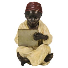 Bronce pintado en frío de principios del siglo XX titulado "Niño escribiendo" de Franz Bergman