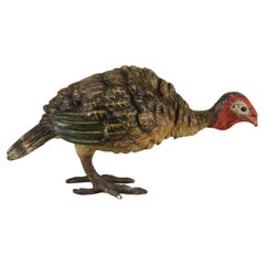Bronce pintado en frío de principios del siglo XX titulado "Alimentando al pavo" de Bergman