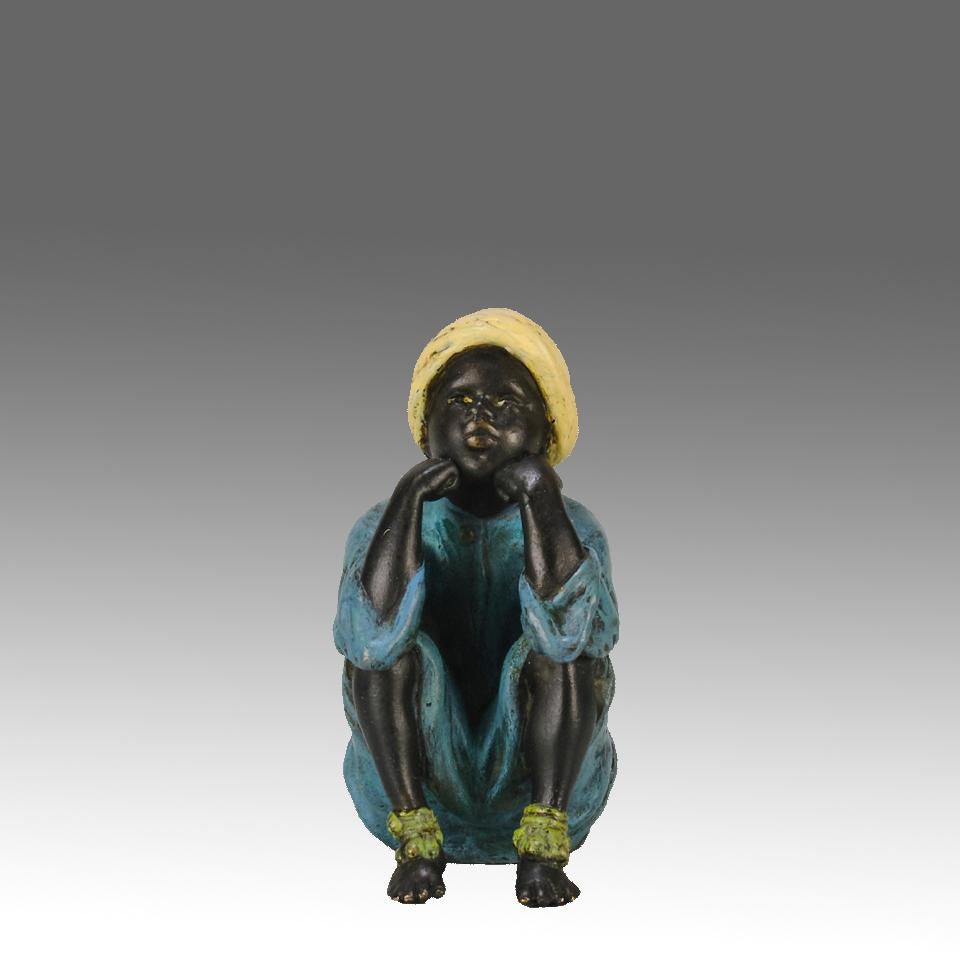 Raffinata figura in bronzo austriaco dipinta a freddo dei primi del Novecento, raffigurante un giovane arabo in abiti orientalisti d'epoca, seduto con la testa appoggiata sulle mani in preda a profondi pensieri, firmata Bergman 