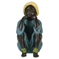 Bronce pintado en frío de principios del siglo XX titulado "Niño sentado" de Franz Bergman