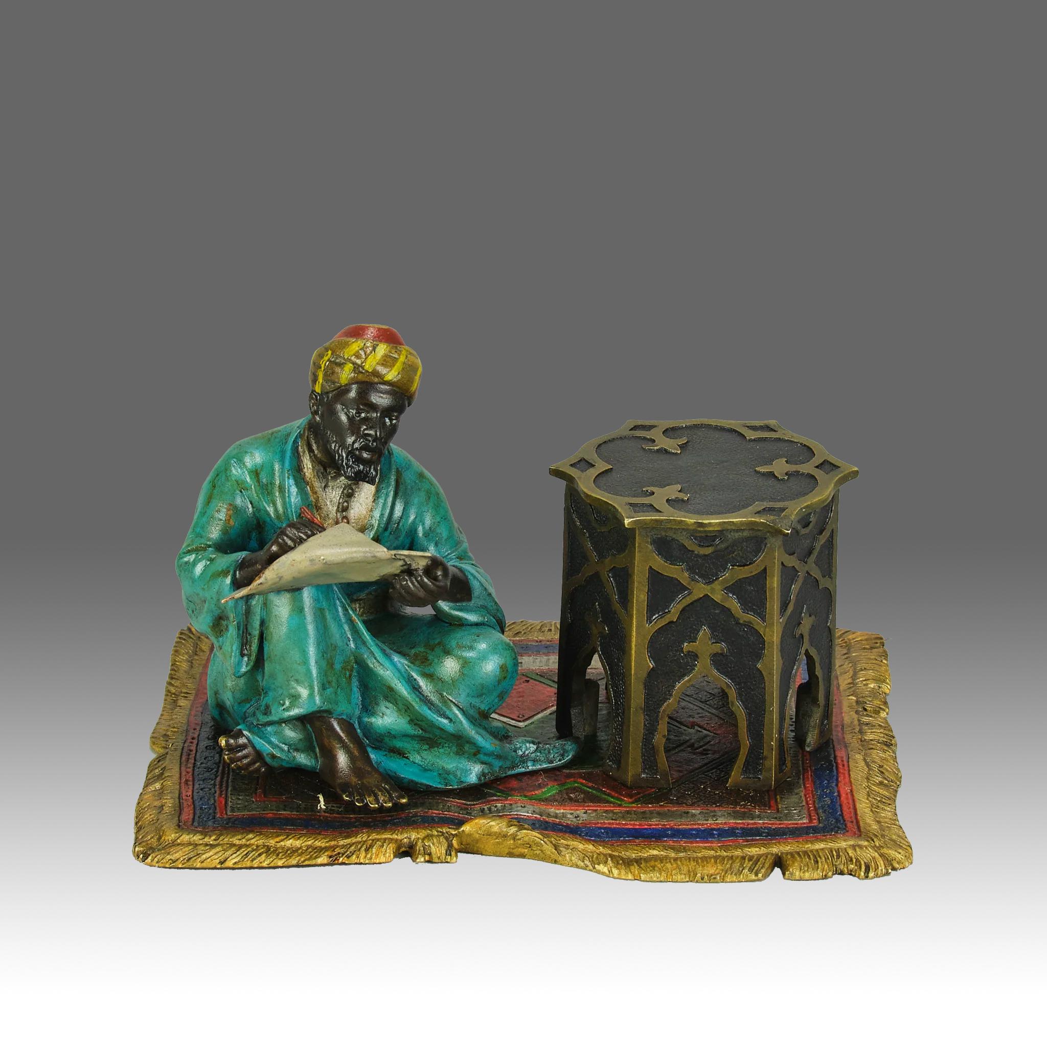 Eine exzellente österreichische Bronzestudie des frühen 20. Jahrhunderts mit Kaltbemalung, die einen arabischen Mann zeigt, der auf einem orientalischen Teppich neben einem Tisch sitzt und schreibt. Die Bronze mit exzellenter lebendiger Farbe und