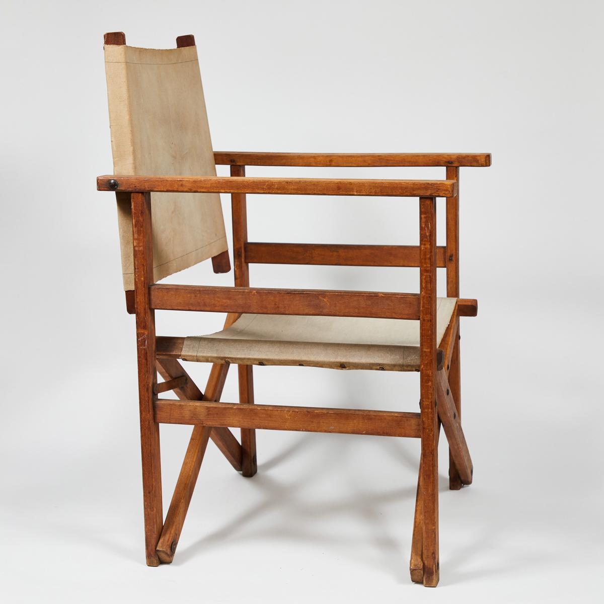 Early 20th-century collapsible wooden director's chair from England. With original cream-colored canvas seat and small metal bolt details, this design classic has great patina and an outdoorsy appeal.

England, circa 1900

Dimensions: 21.5W x 22D x