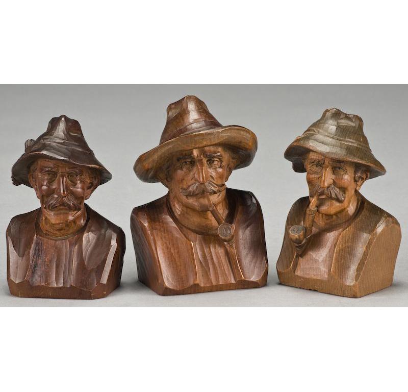 This antique set of black forest wood figures was created in Switzerland, circa 1900. Hand carved from walnut, oak and pine, the collection features nine carved sculptures: three old men busts with hat, and six wood figures including hunter,