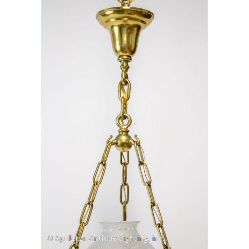 Traditional early 20th century Colonial brass pendant. Has original frosted and cut glass shade. Brass fixture in the shape of an old argand lamp, but originally electric. Very good quality.

Material: Brass, glass
Style: Colonial,