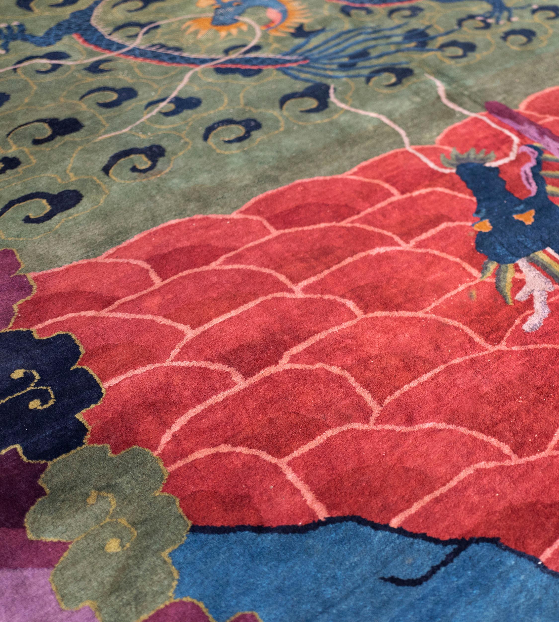 This antique Handwoven Chinese rug has a field with a central rectangular panel, the lower section with a bright orange-red part lozenge interlocking design with a central aubergine-purple pole with a stylized dragon climbing upwards, the above