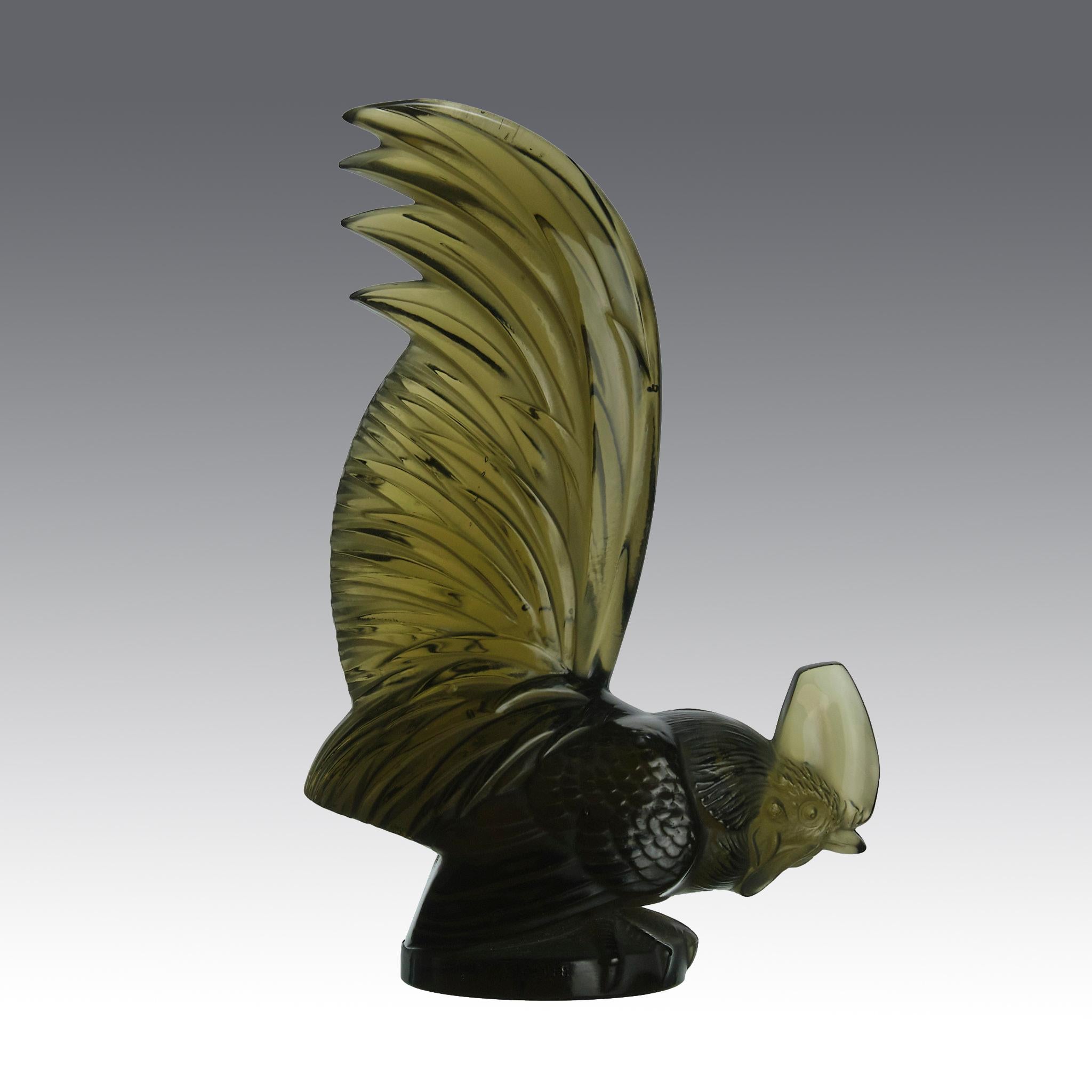 Rare mascotte de voiture en verre topaze foncé, représentant un coq en train de se nourrir, avec de fins détails finis à la main, notamment au niveau des plumes du corps. Signé R Lalique et France. 

Coq Nain
Numéro de catalogue : 1135
Signature