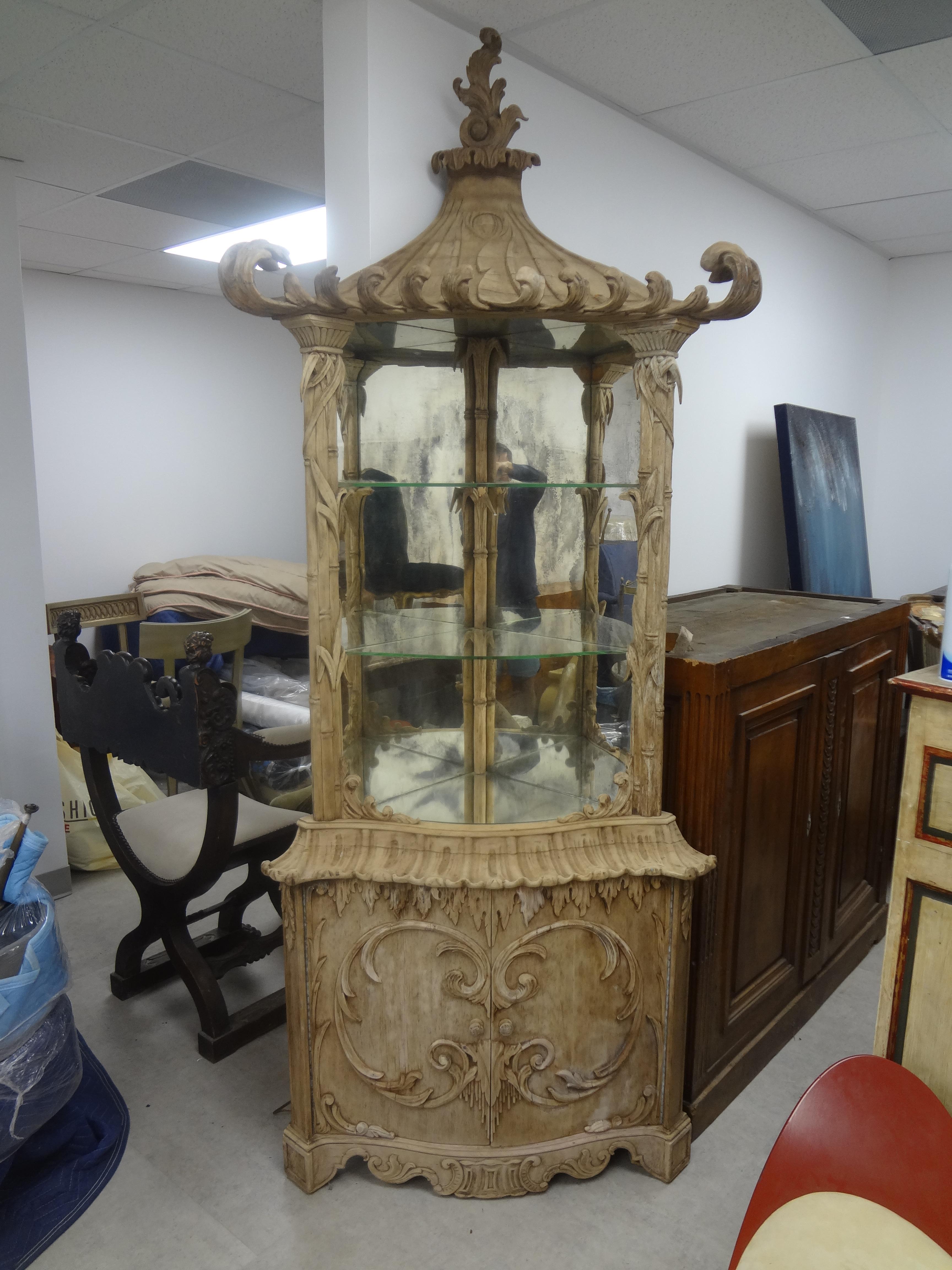 Chinese Chippendale pagoda corner cabinet. This sensational early 20th century continental carved bleached wood chinoiserie pagoda cabinet has a mirrored display area with glass shelves at the top with storage below. This stunning versatile cabinet