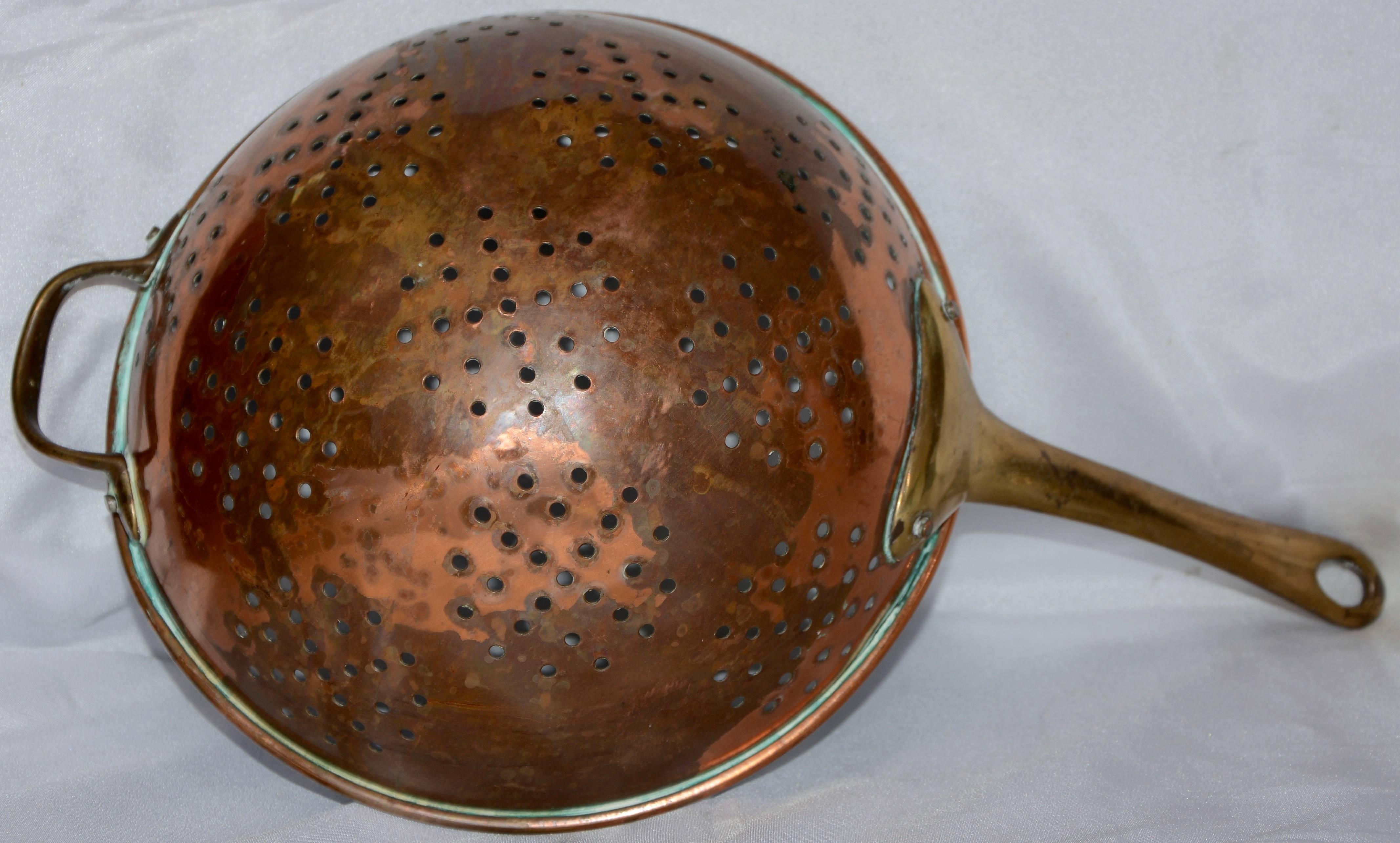 Hand-forged brass handles accent this copper colander from France. The inside is lined with zinc and an array of holes make an interesting design.