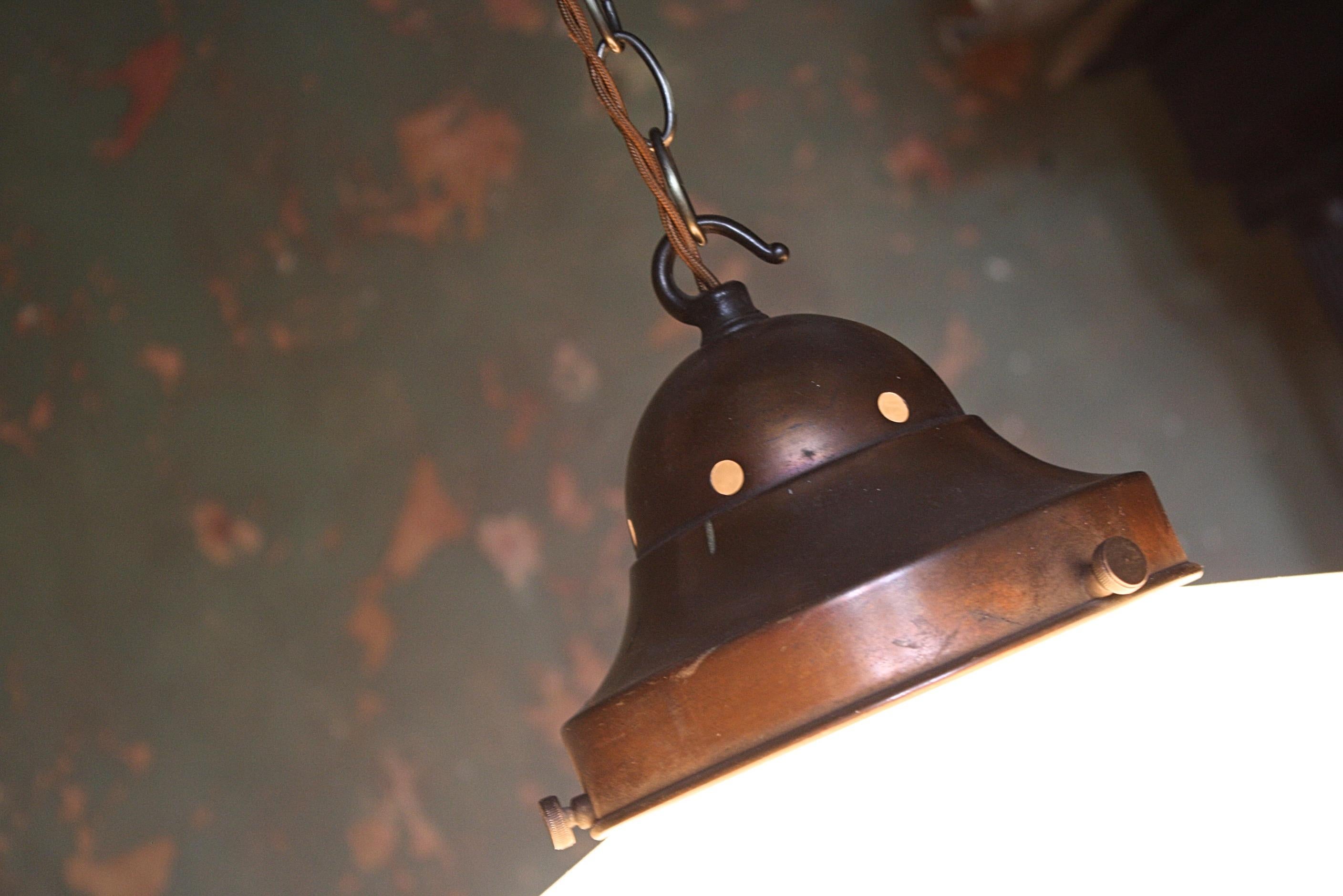 A large shaply opaline glass pendant, with its original spun copper gallery. Removed from Bush's Opticians in Hessle 

The glass is in perfect condition, the copper gallery has a warm natural patina, replacement aged chain (approx 1m) and ceiling