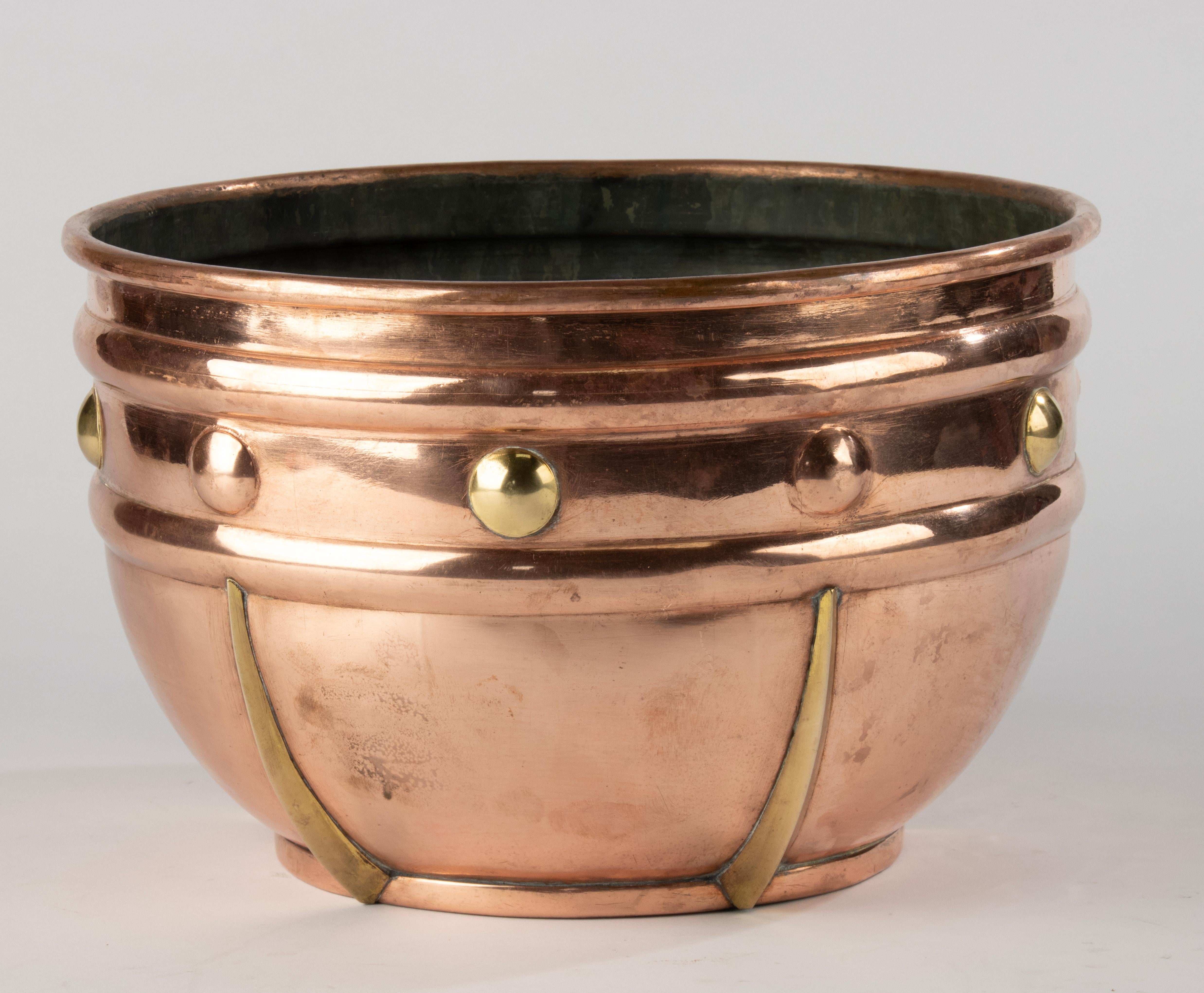 A beautiful round planter made of copper over zinc, dating from around 1920. The piece features bold brass rivet and strap details and has developed a rich, warm patina over time. Its clean, sculptural form makes it suitable for both traditional and