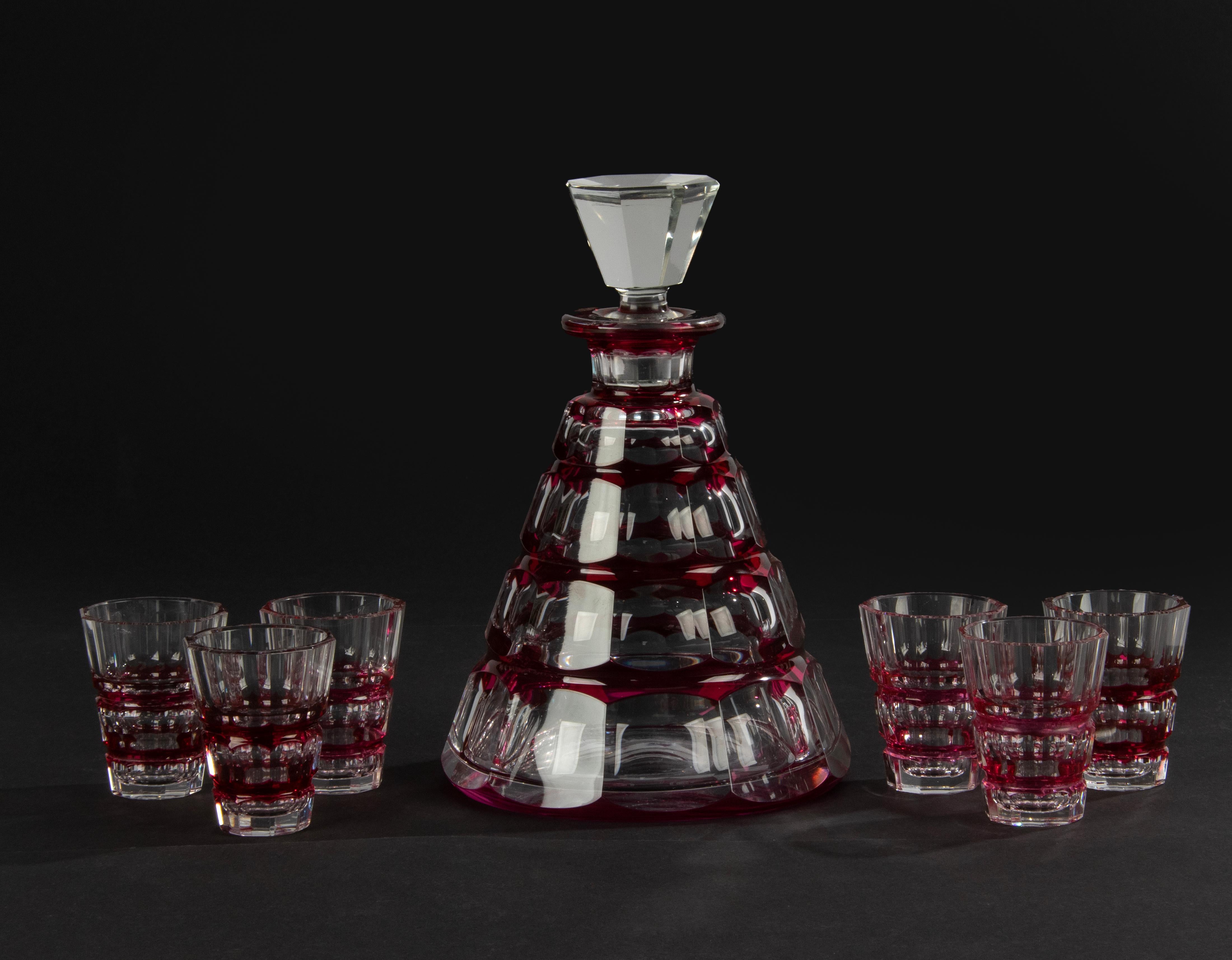 Une belle carafe en cristal avec six verres assortis, fabriquée par la marque belge Val Saint Lambert. Belle combinaison de couleurs de cristal rouge et clair, joliment taillé. La carafe n'est pas marquée (les pièces de cette période de VSL ne sont