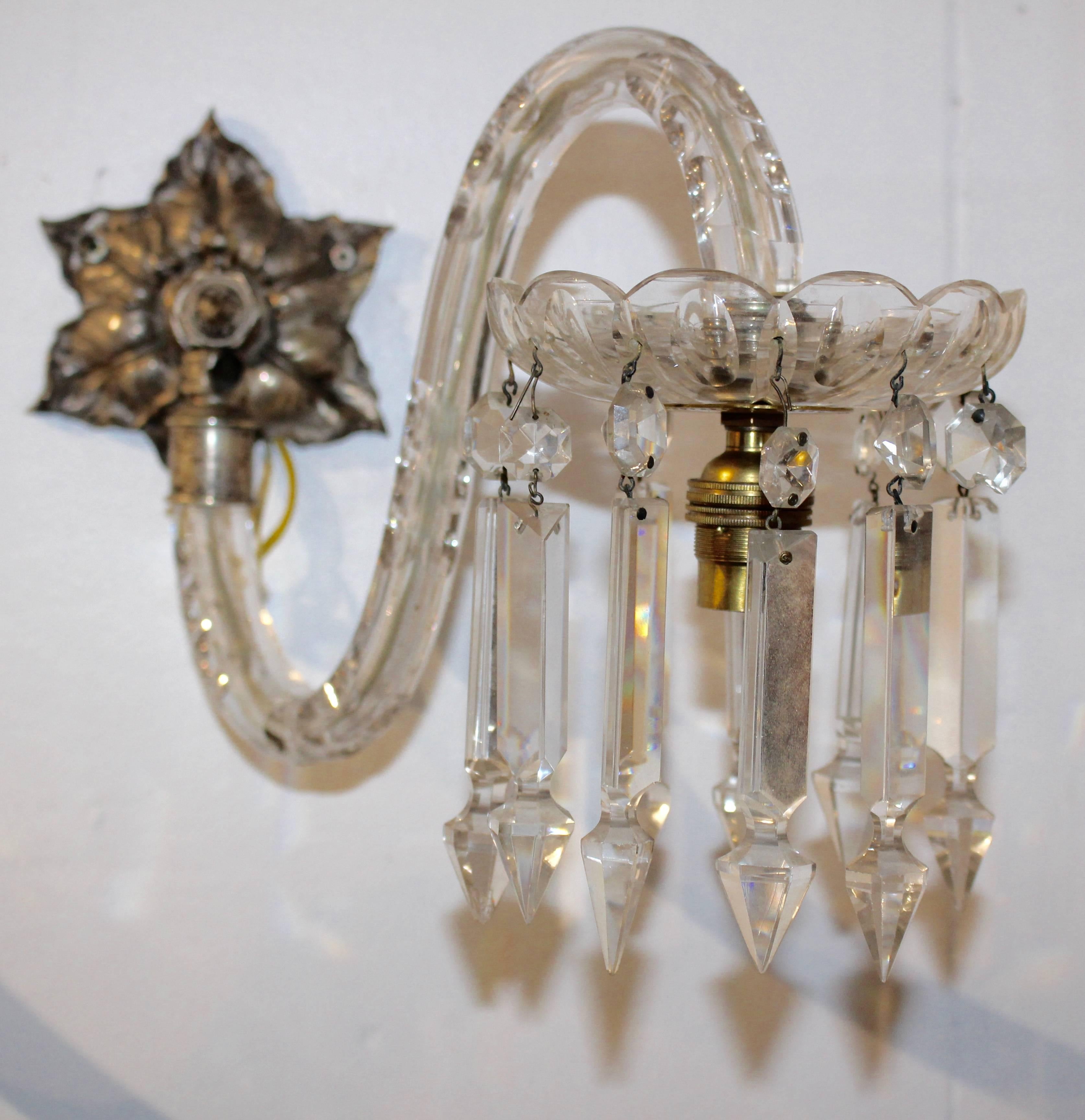 Extremely attractive and impressive sconces feature finely cut crystal prismatic spear drops, and silver plated fittings. The wall plates have a pretty intricate six leaf design and the beautifully curved arms having handcut detail. The lights can