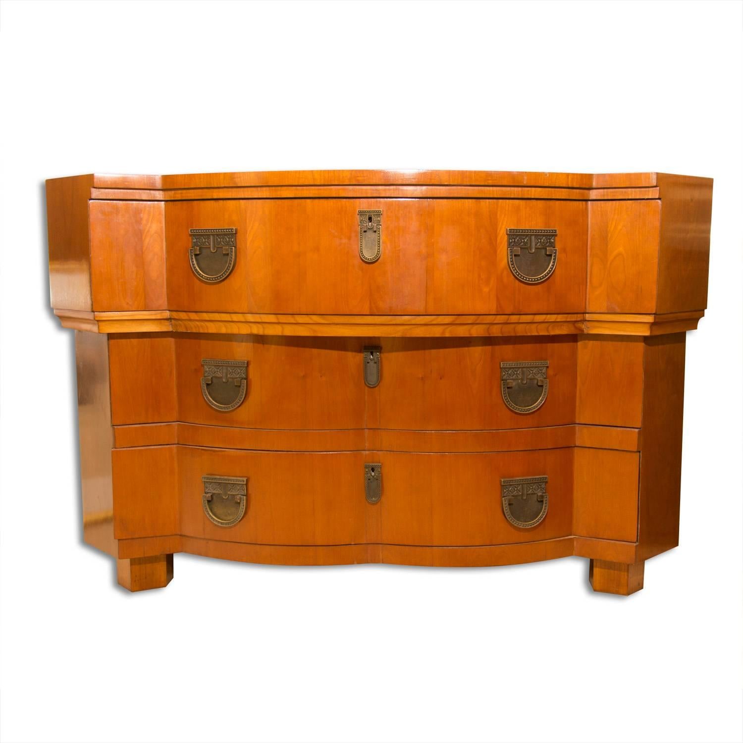 Commode cubiste robuste du début du 20e siècle aux formes particulières, elle a été fabriquée dans l'ancienne Bohême, plus précisément sur le territoire de l'Autriche-Hongrie d'alors
Le coffre est en bois de cerisier et comporte une garniture en