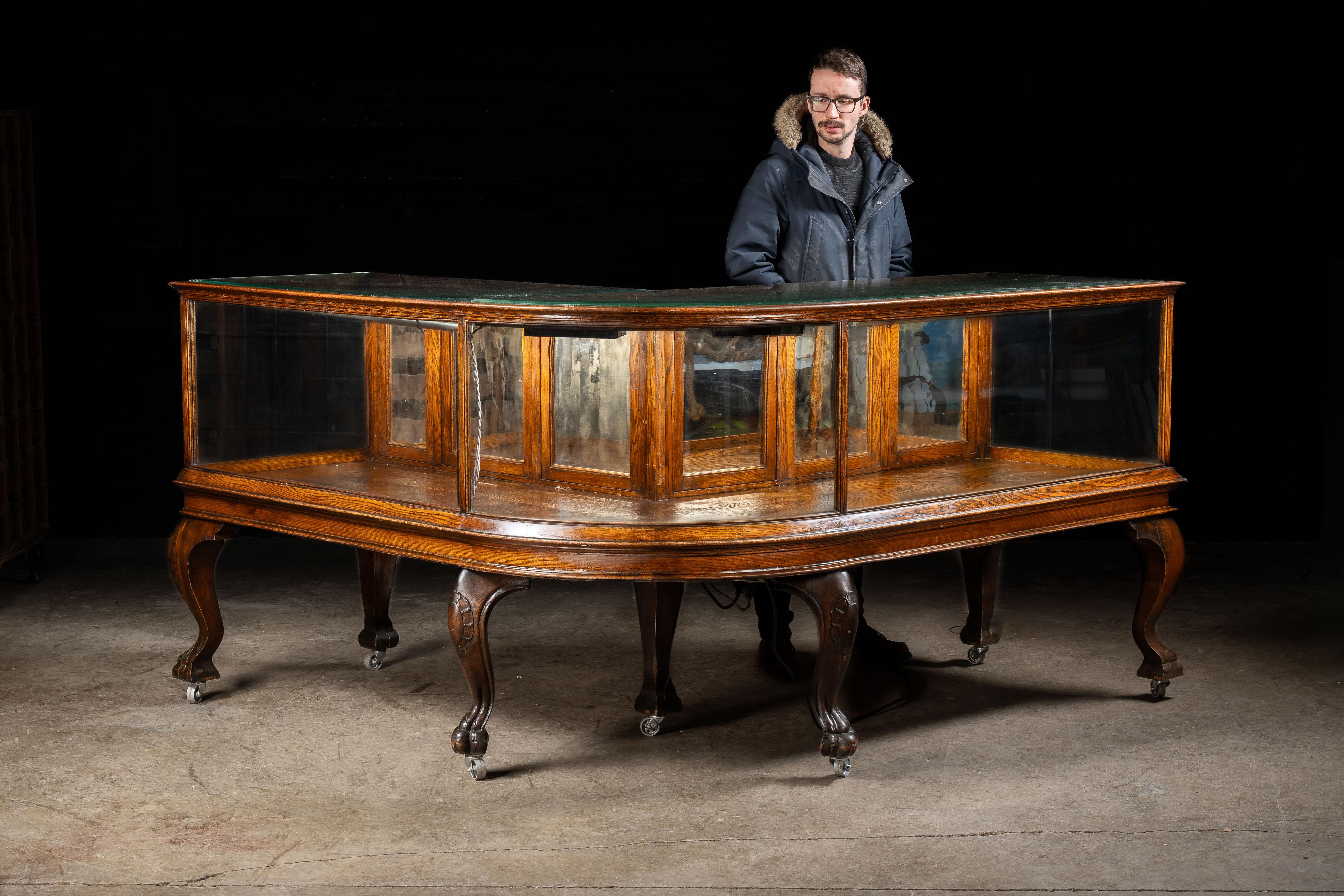 Antique wood and glass vitrine.

When it comes to magnificent pieces, this gorgeous oak woodwork starts at the top and extends down its clawfoot cabriole legs. Four main window panels make up the front and sides, with the front-most glass panel