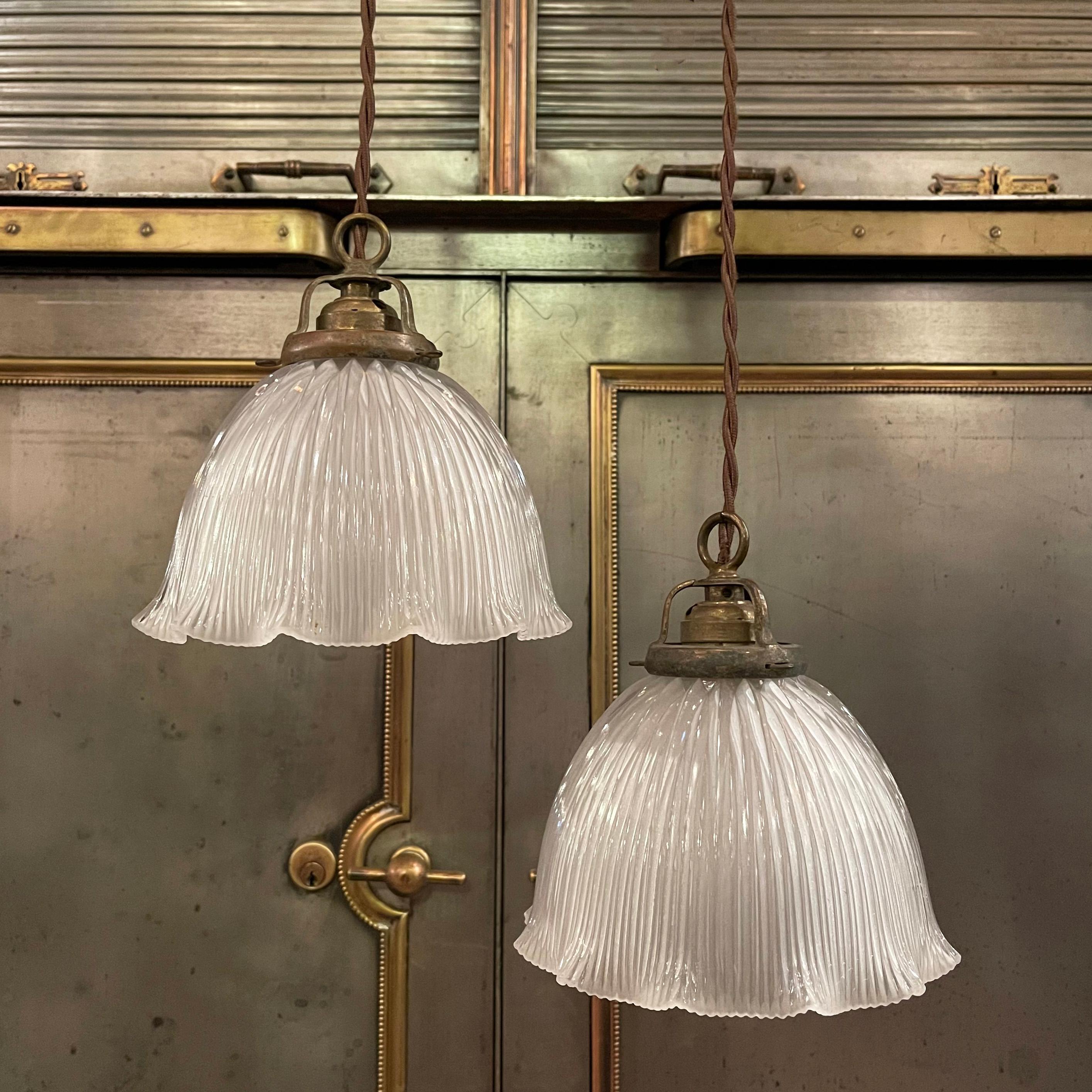 Early 20th century pendant light with a ruffled edge, cut glass dome shade and brass hardware is newly wired with 48 inches of brown braided cloth cord. Three pendants are available, priced individually.