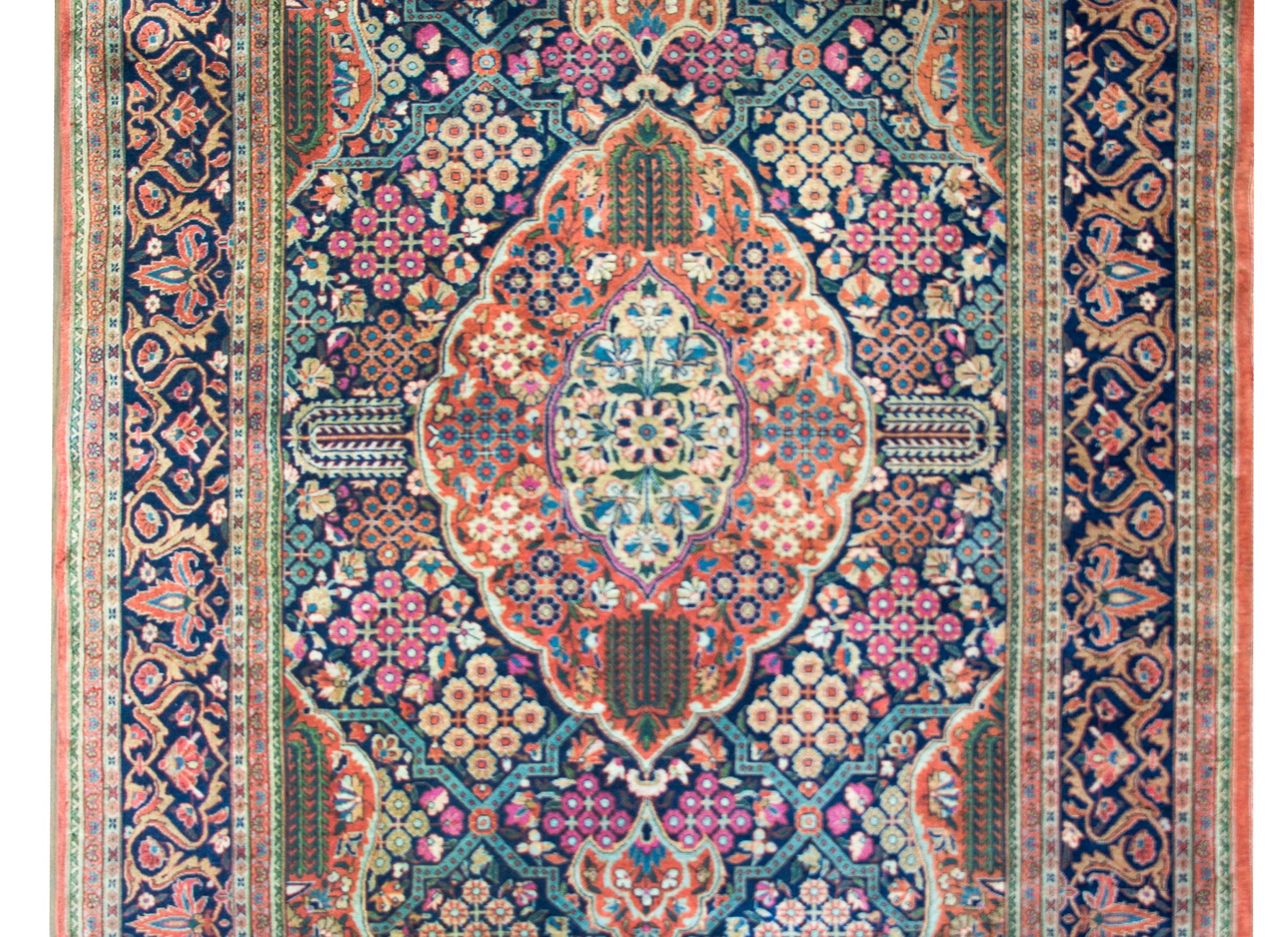 A stunning and rare early 20th century Dabir Kashan rug with the most incredible mirrors pattern with myriad willow trees, and stylized geometric patterned flowers all woven pink, light and dark indigo, cream, orange, and crimson.  The border is