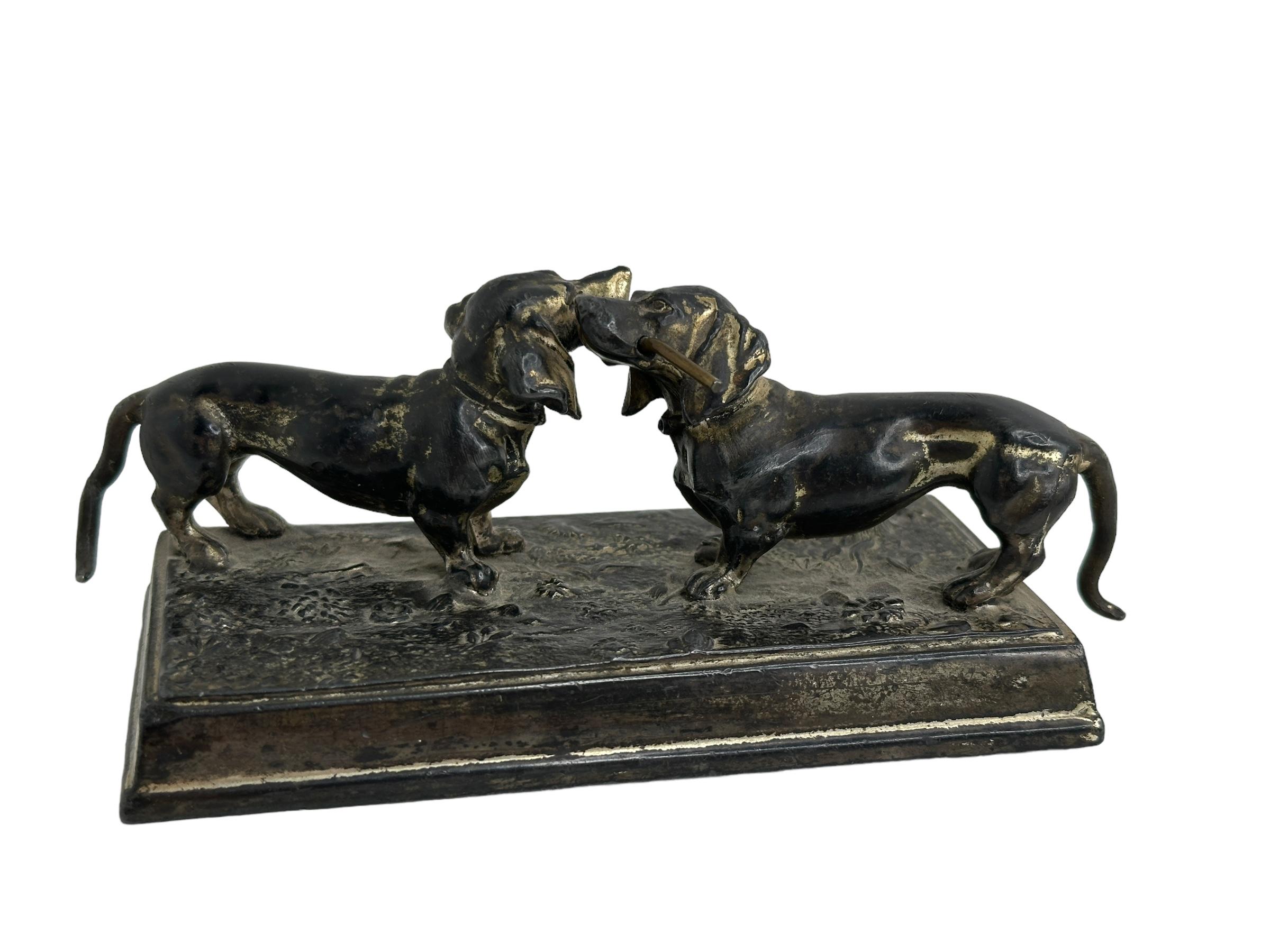 Classic early 1910s metal (bronze) figurine. Shows two dachshunds fighting over a stick. Found at an estate sale in Nuremberg, Germany. Marked with Germany.
A nice addition to any collection. You can use it also as paperweight at your table. 