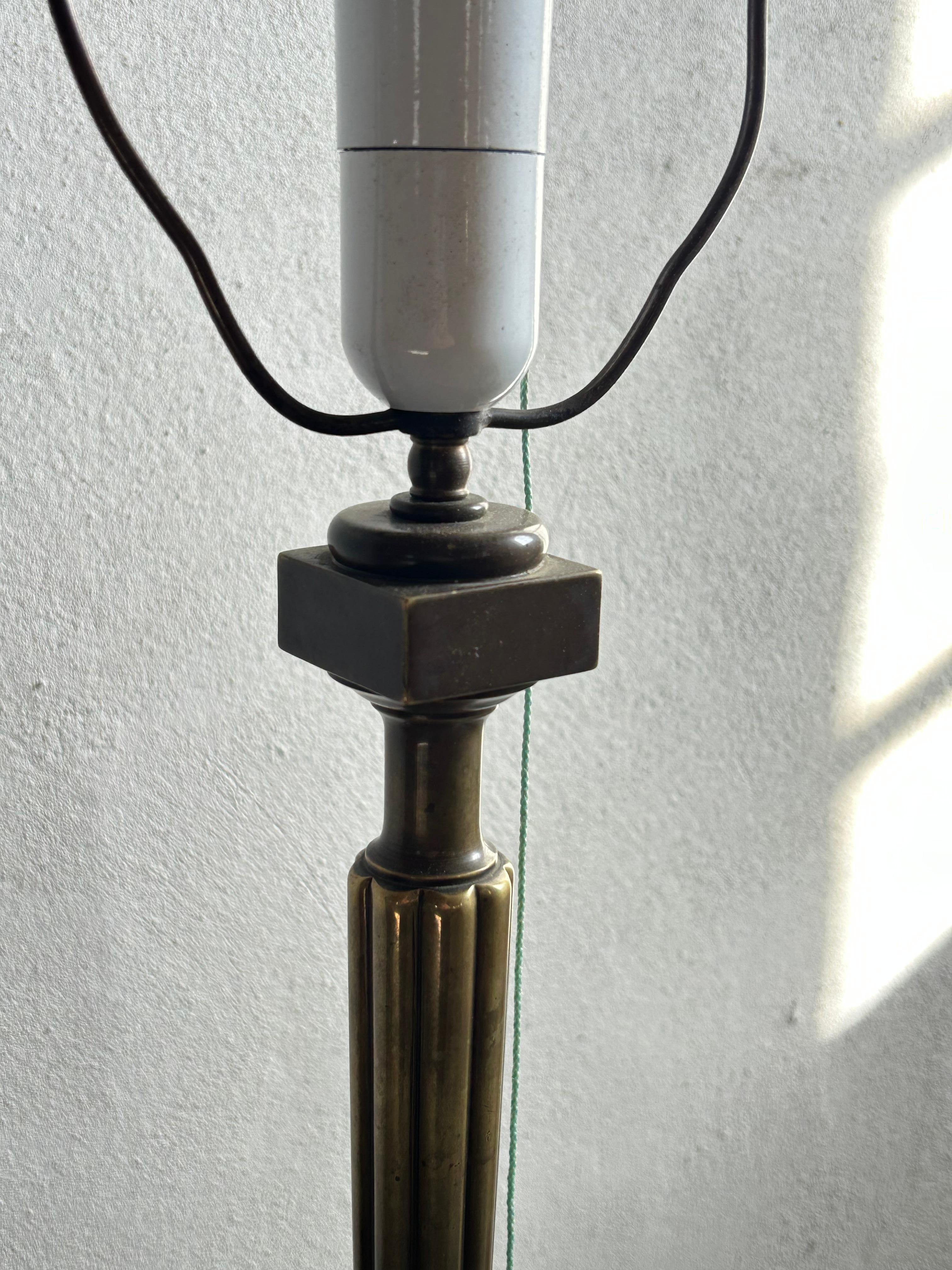 Une lampe de table danoise en bronze, raffinée et élégante, du début du 20e siècle. La lampe présente une surface en bronze magnifiquement patinée et des détails d'inspiration néoclassique, notamment une colonne cannelée et une base circulaire à