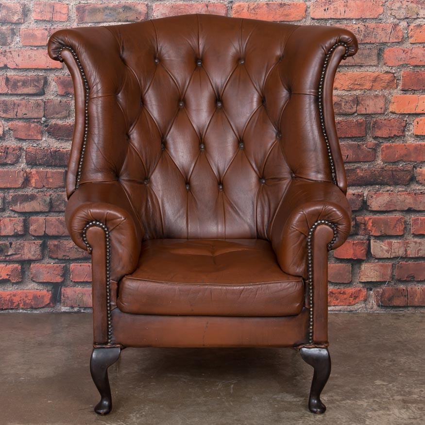 This circa 1920 mottled brown leather wingback chair from Denmark is in well-kept original condition, and sits nicely. This is a handsome chair with a tufted back, rolled arms and resting on four cabriole legs. The leather has minor creases,