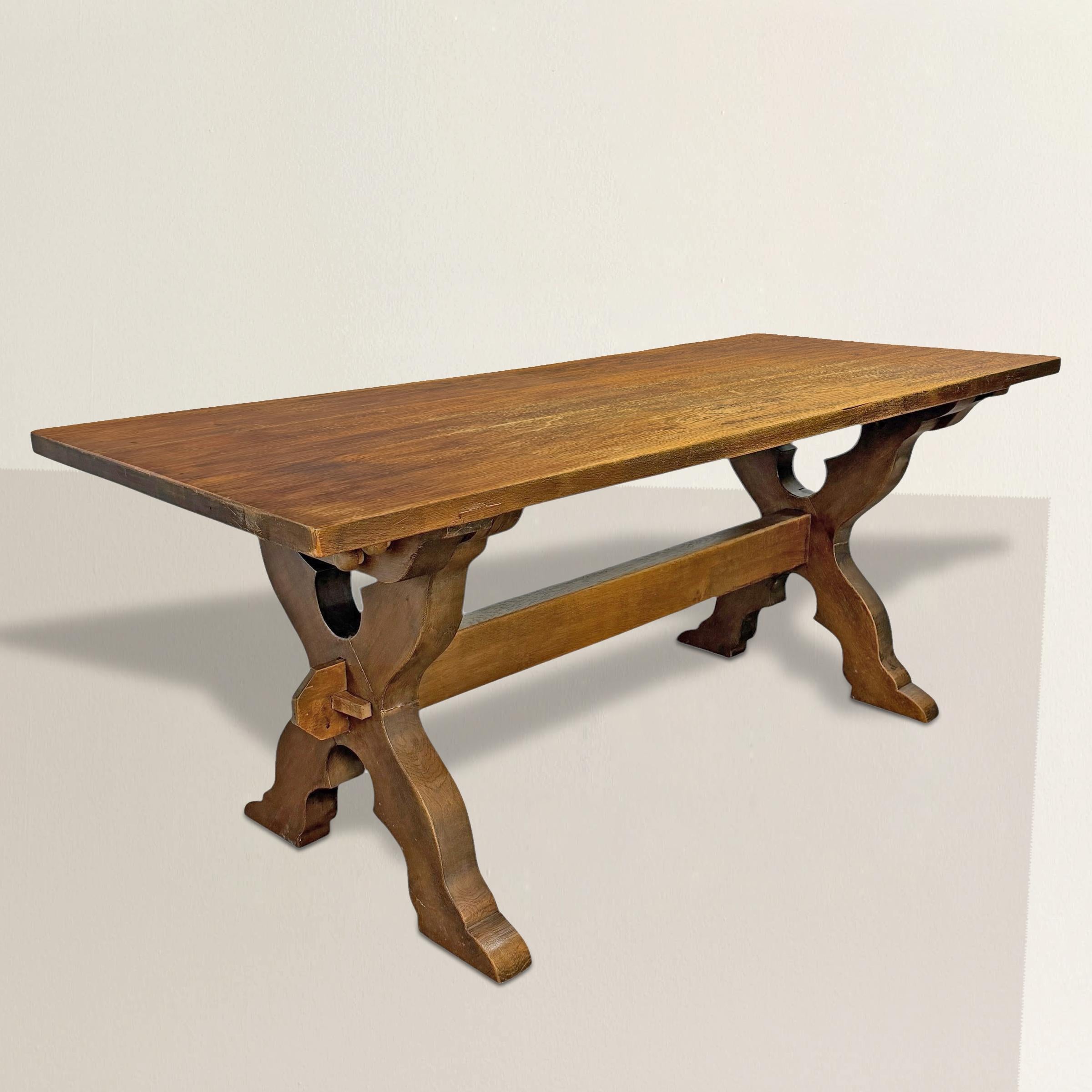 Una mesa de caballete danesa de principios del siglo XX, circa 1900-1920, hecha a mano con gruesos tablones de roble macizo y construida con una claridad de propósito que parece claramente nórdica. La mesa se desmonta por completo -su tablero fijado