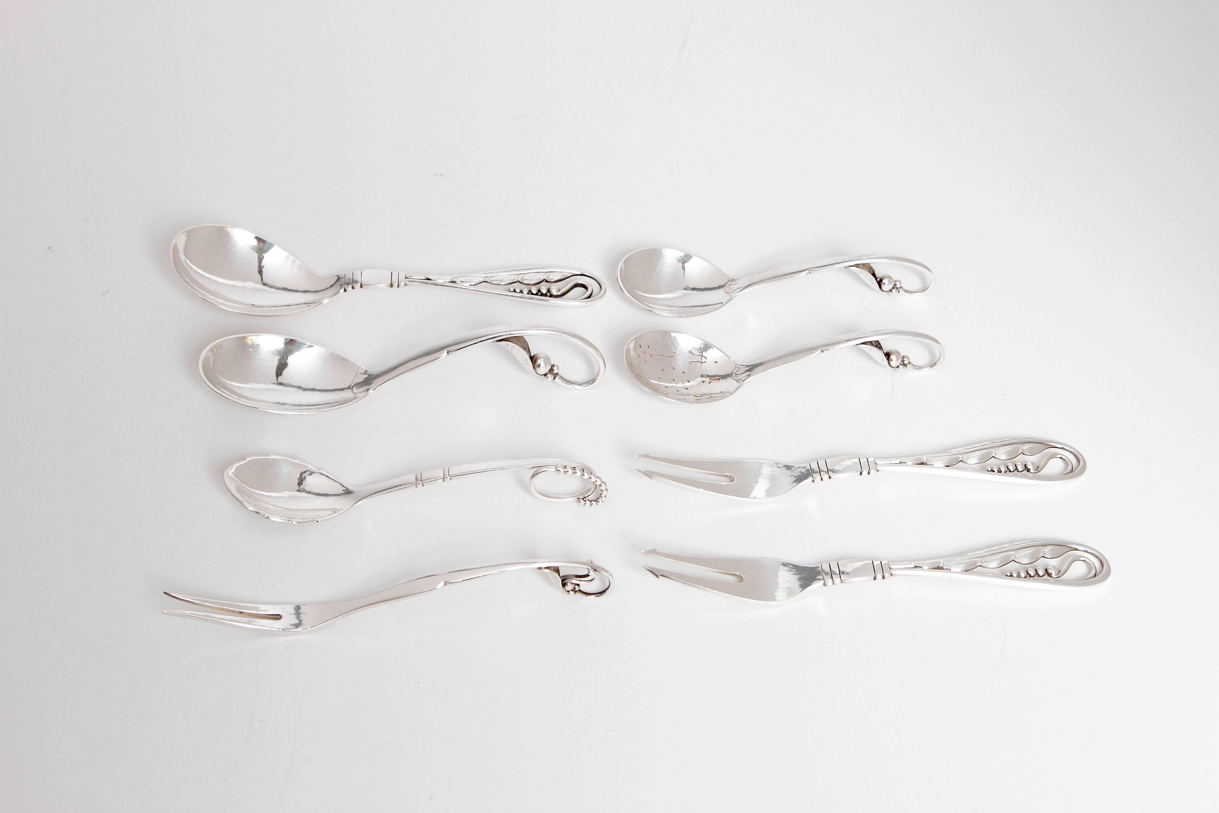 Spoons and forks sold as a set of six or separately.
Left: Georg Jensen soup spoon in the blossom pattern no. 42. The soup spoon is 5 78