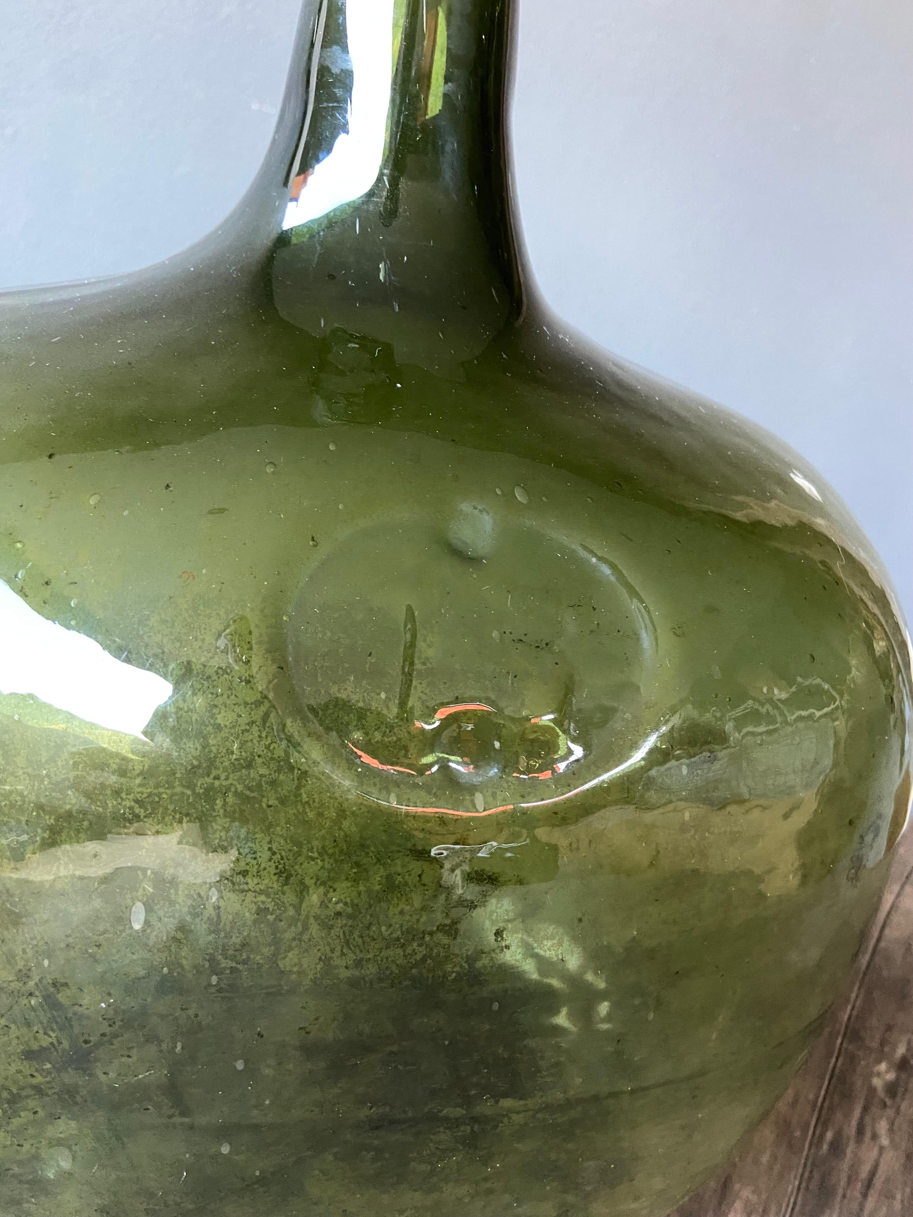 Early 20th century hand-blown demijohn bottle from the border area of Puebla and Oaxaca, Mexico. 17 liter marking formed within the glass.