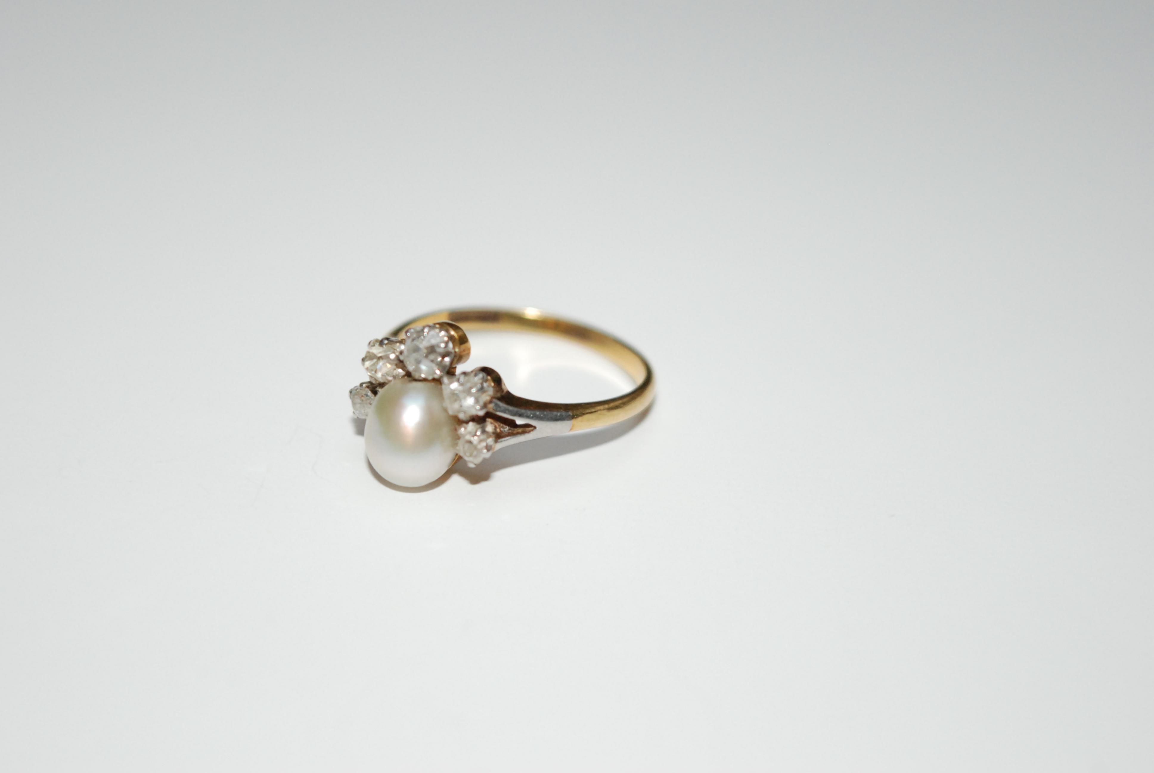 An Early 20th Century 18ct gold and platinum pearl and old-cut diamond ring. 

Estimated total diamond weight 0.40ct



Ring size M 1/2

Weight: 3.4g
