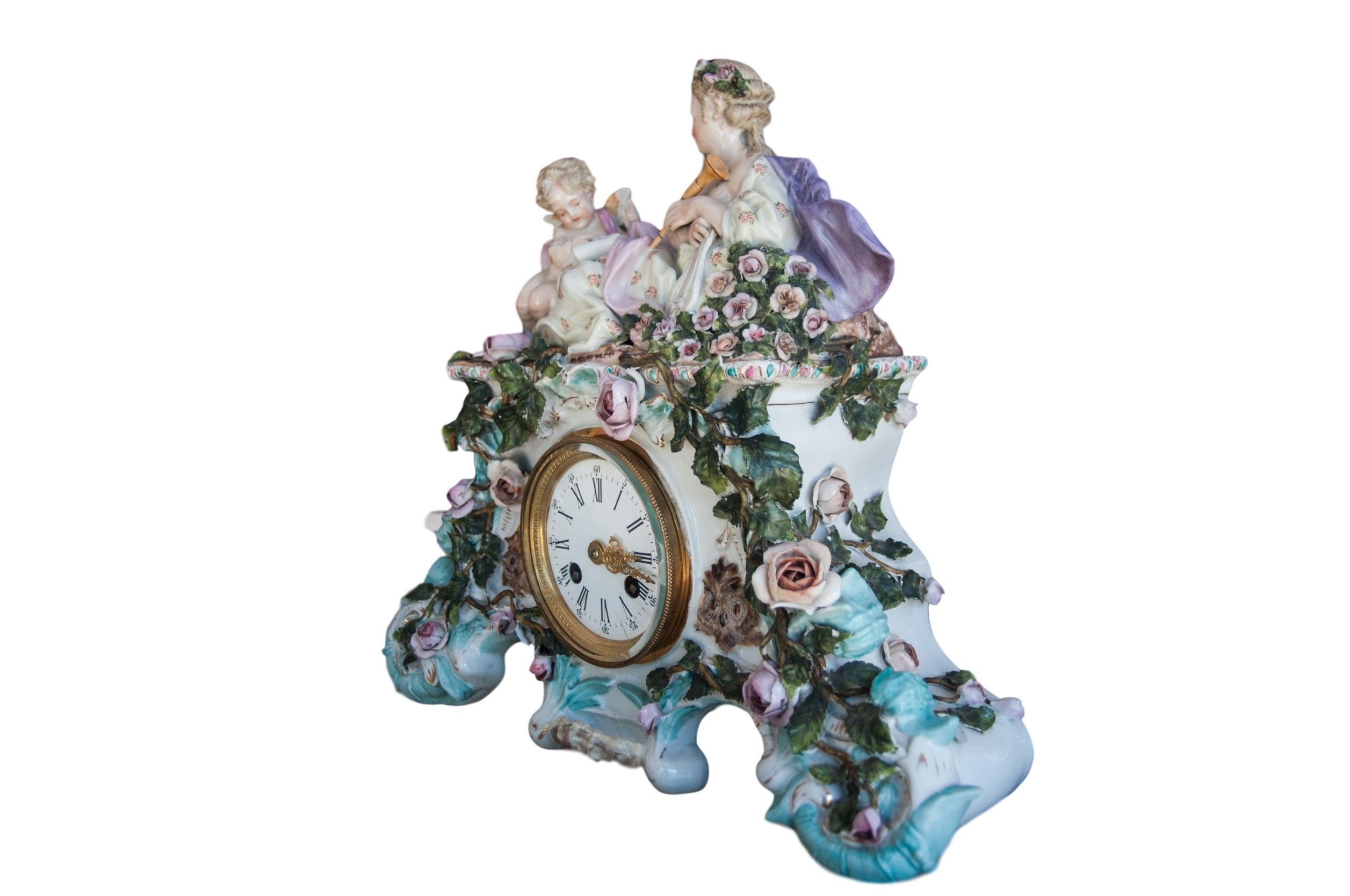 Early 20th century Dresden Porcelain clock depicting reclining woman in a bed of roses having Eros, the deity of love reading sheet music to her, trying to inspire her to play her harp that lies at her side. Very good condition. Tiny minute chips on