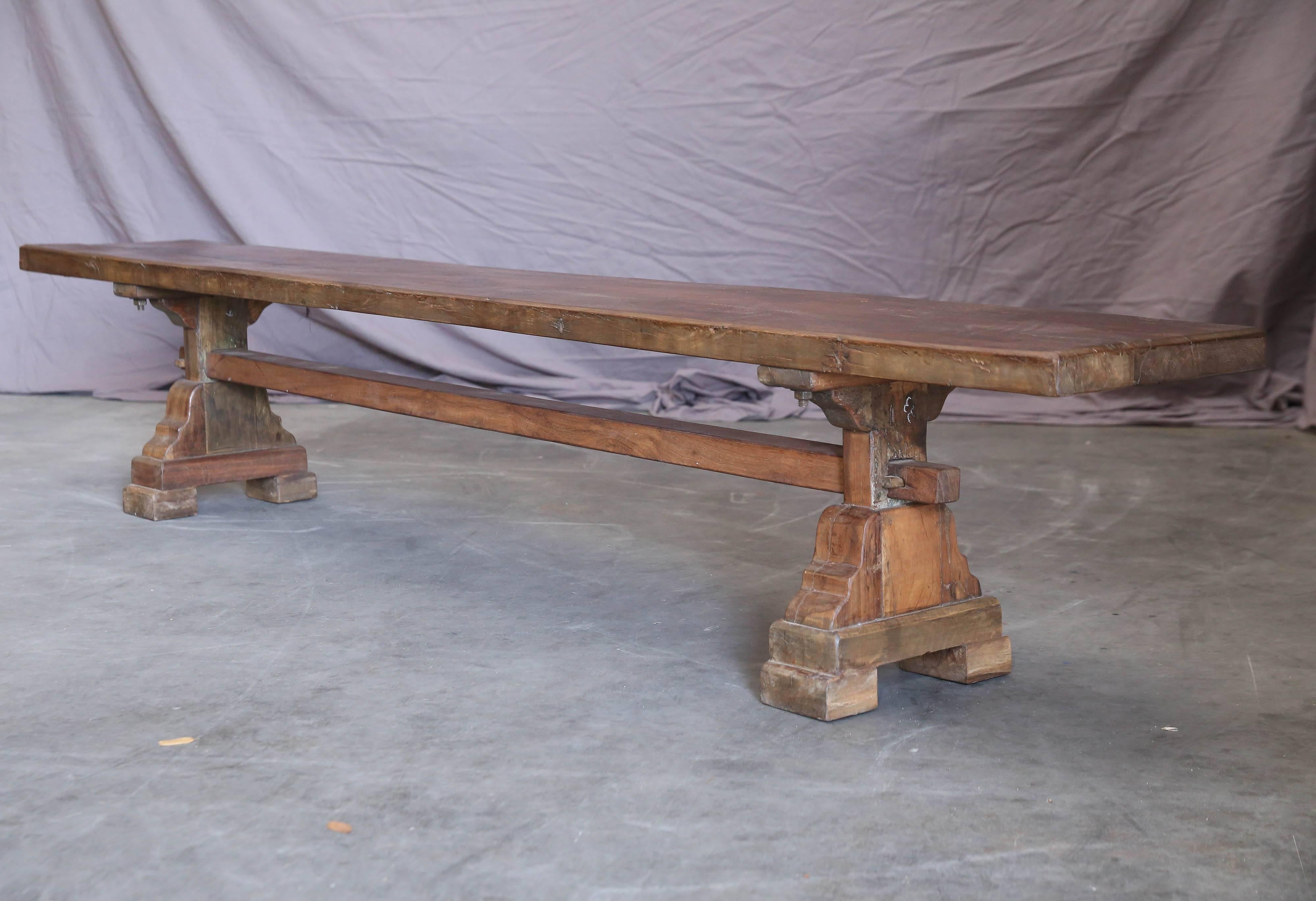 It is a flat bench with a solid thick top supported on two pedestals on either end. It is heavily built in the old world carpentry with immaculate dovetail joints. Benches like this one will last several generations. It stood the test of