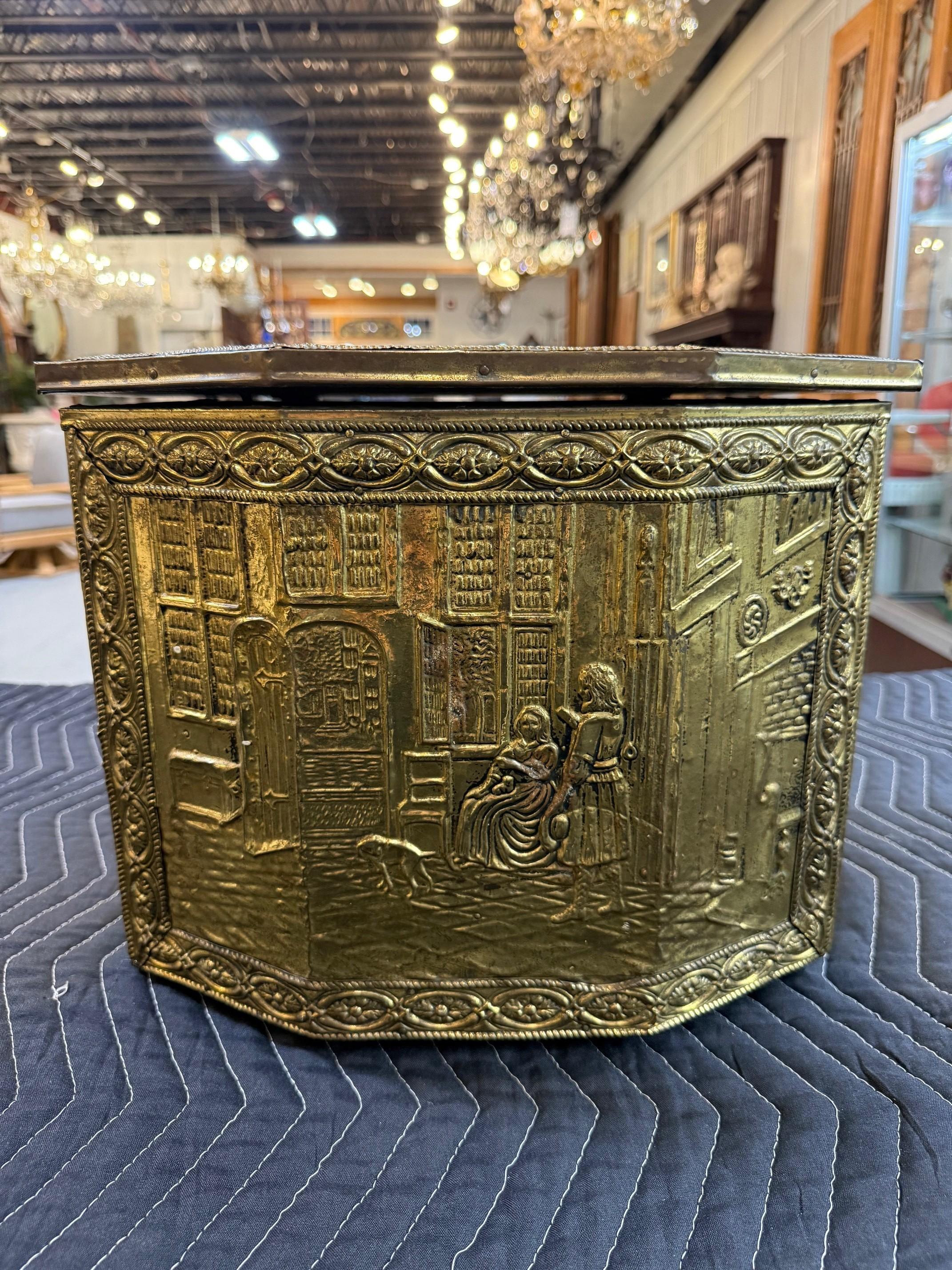 Antique Dutch fireside coal, tinder box, bin or scuttle, made of hardwood and clad in brass, embossed with a textured checkered motif on the sides and manor scene on the front and a tavern scene on the lid, framed in a border of tulips. Includes