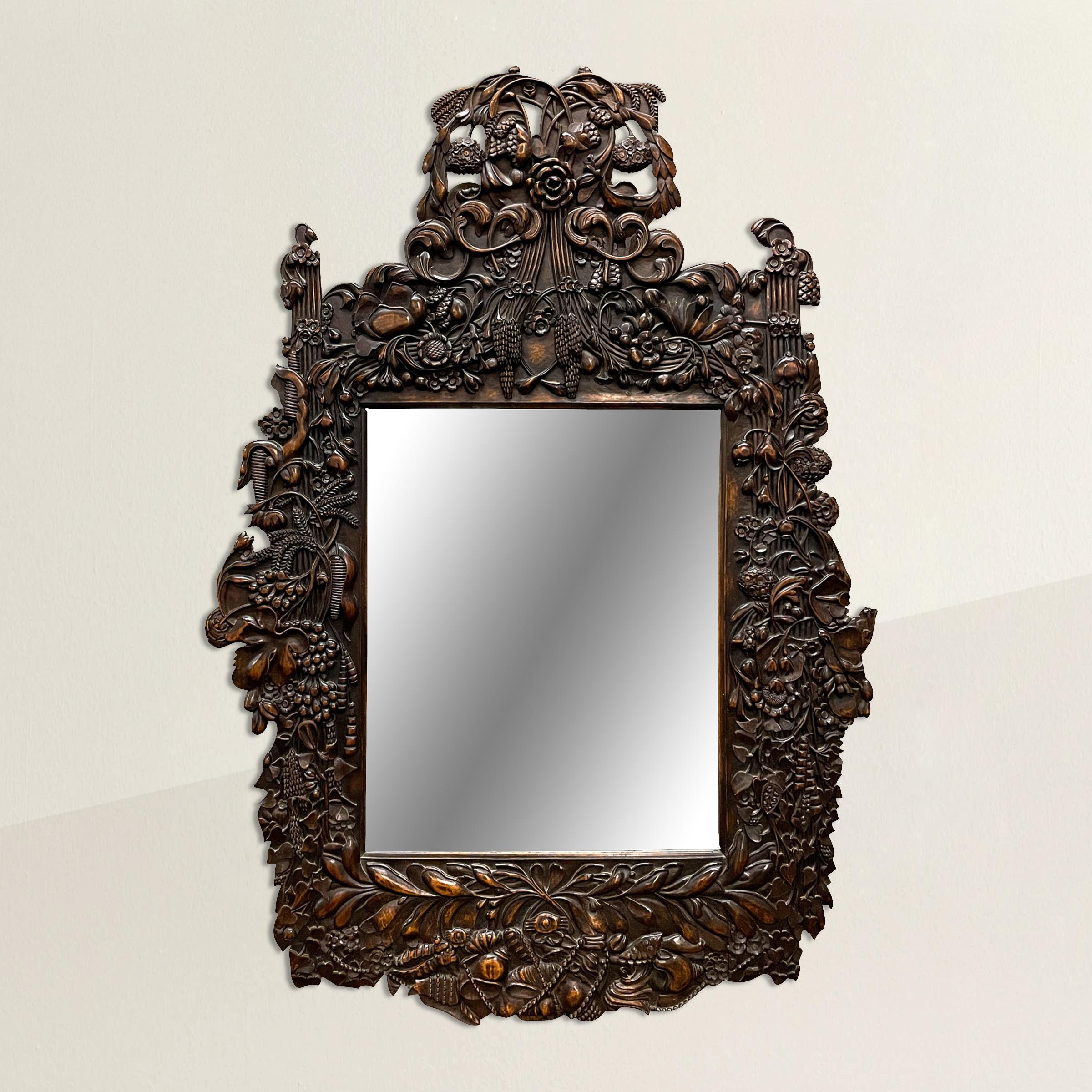 An incredible early 20th century Dutch mirror with the most wonderful hand-carved wood frame depicting myriad flowers including chrysanthemums, roses, and lotus, and other flora including sheafs of wheat, fig leaves, cattails, and ivy, and with a