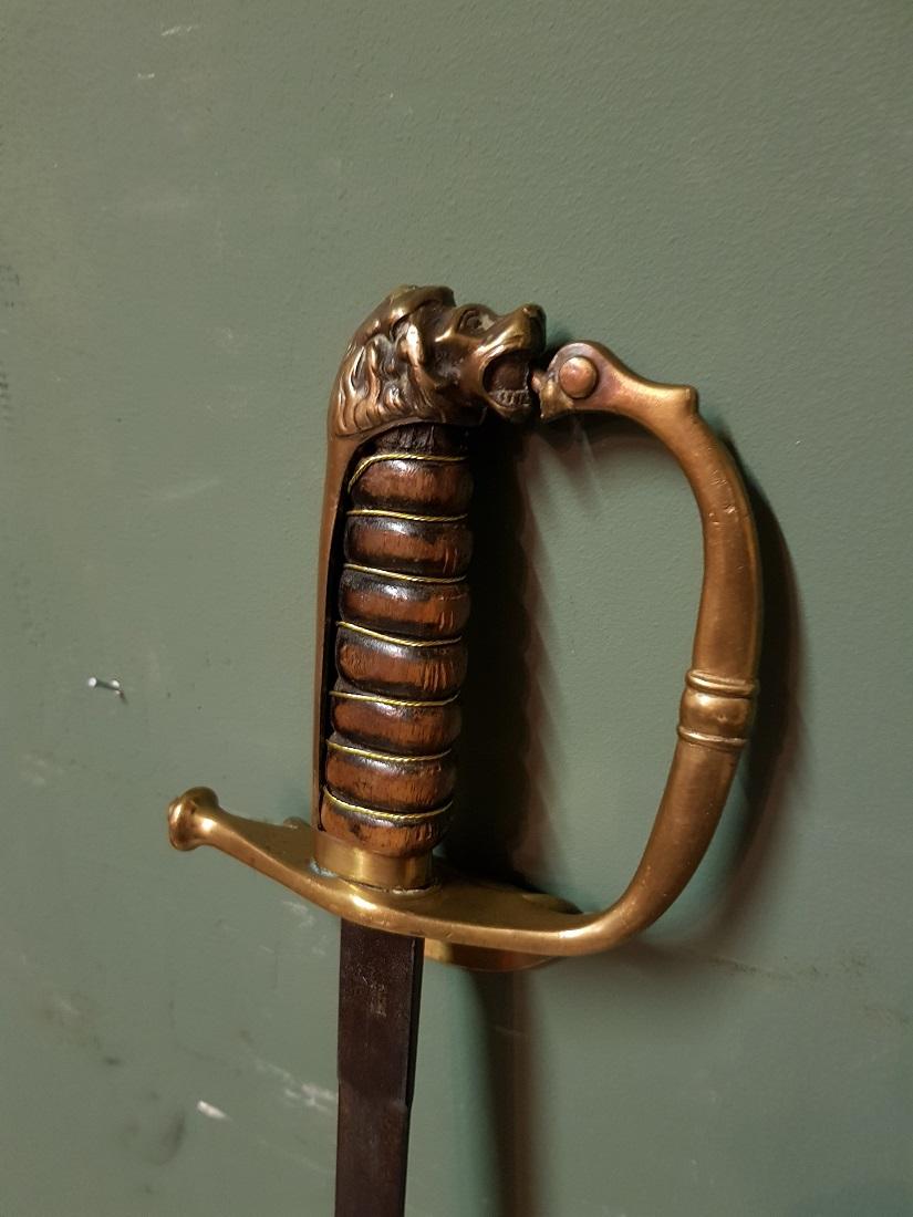 Antique Dutch sword without the sheath and is decorated with lion's head and the blade with etching marked W K & C and unclear with NED WEAP ... Hair ..., this is furthermore in a reasonable condition. Originating from the end of the 19th century or